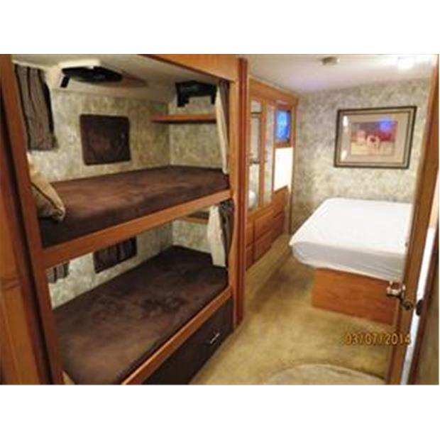 Spacious RV rental interior featuring cozy bunk beds & a private master bedroom for comfortable travel.. Winnebago Sightseer 2007