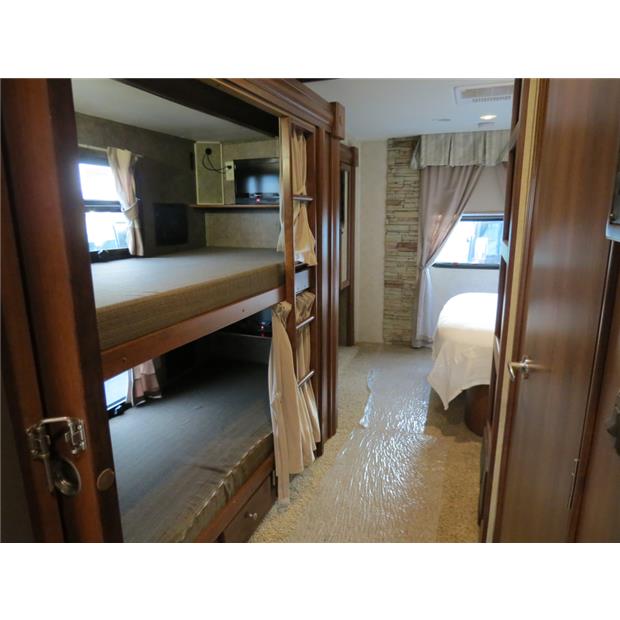 RV rental interior featuring cozy bunk beds and a private bedroom, with protective plastic covering the floor.. Forest-River Georgetown 2014