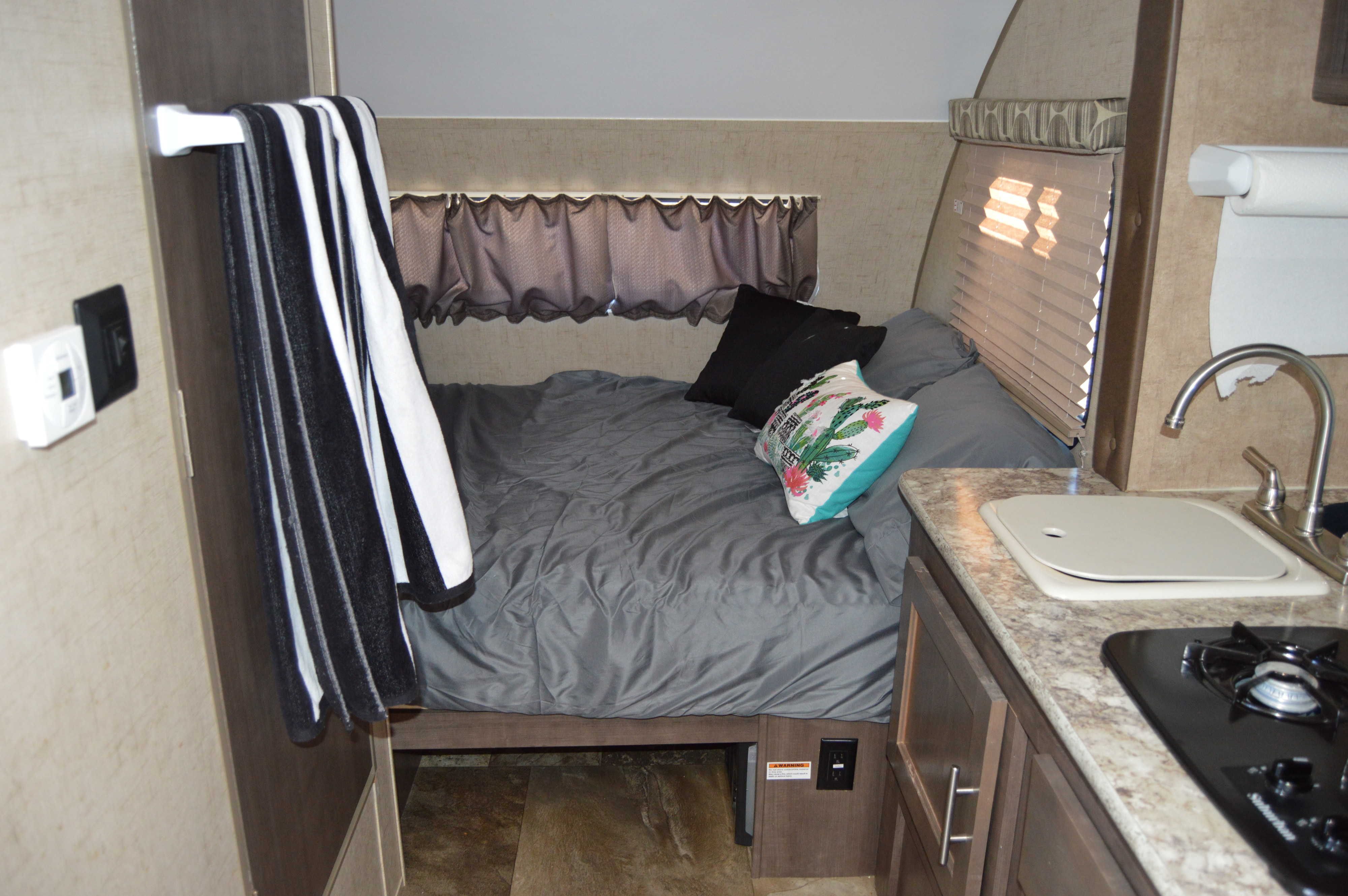 RV rental: View of a compact RV interior featuring a comfy bed, functional kitchen with sink/stove, and window blinds.. Forest River Flight SLX 7 2015