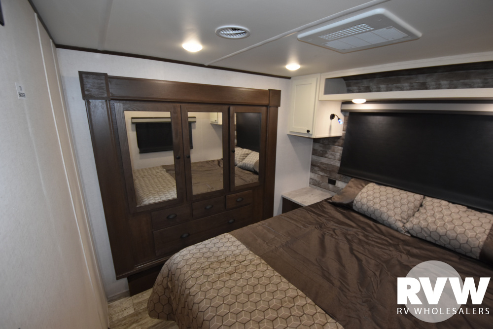 Inside an RV rental: a well-appointed bedroom featuring a comfortable bed, large mirrored wardrobe, and overhead AC.. Forest River XLR Nitro 35DK5 2020