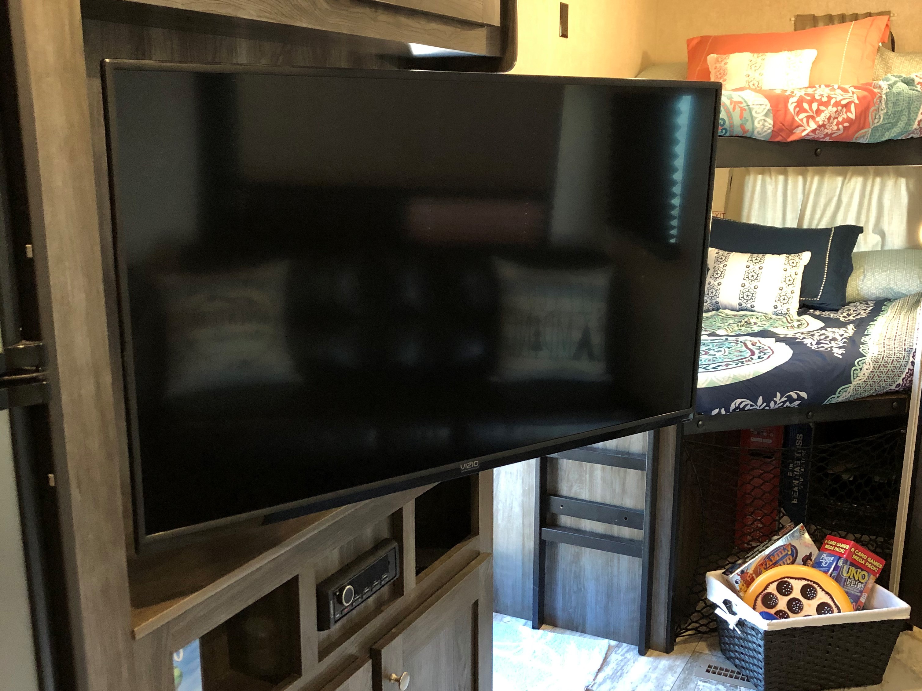 This cozy RV rental features a large Vizio TV, an entertainment console, bunk beds with bedding, and a basket of games.. Highland Ridge RV Open Range 2019