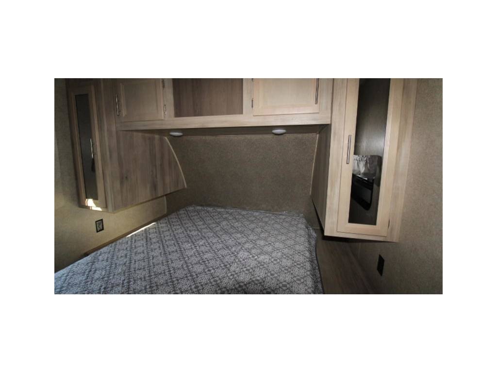 RV rental bedroom shows a bed with overhead cabinets & side closets. Compact and practical interior storage.. Coachmen Catalina 2019