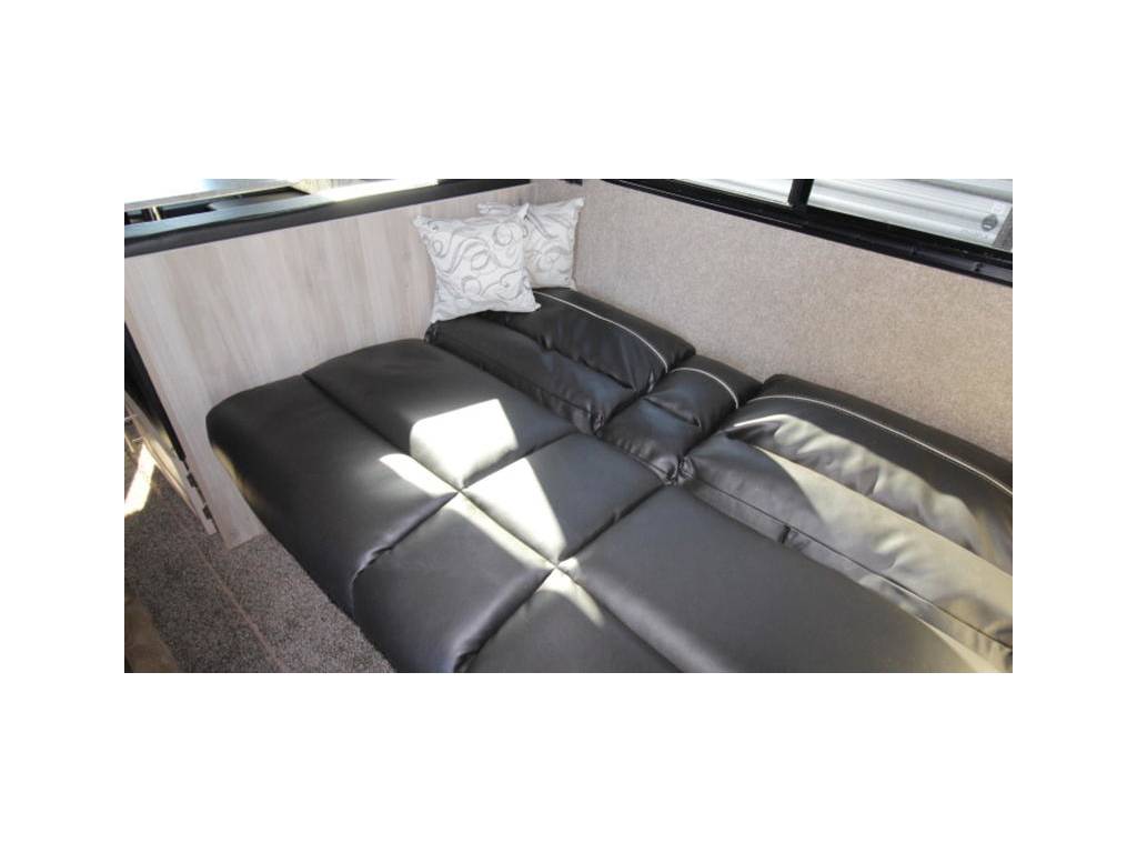 RV rental: black faux leather convertible dinette/bed with decorative pillows.. Coachmen Catalina 2019