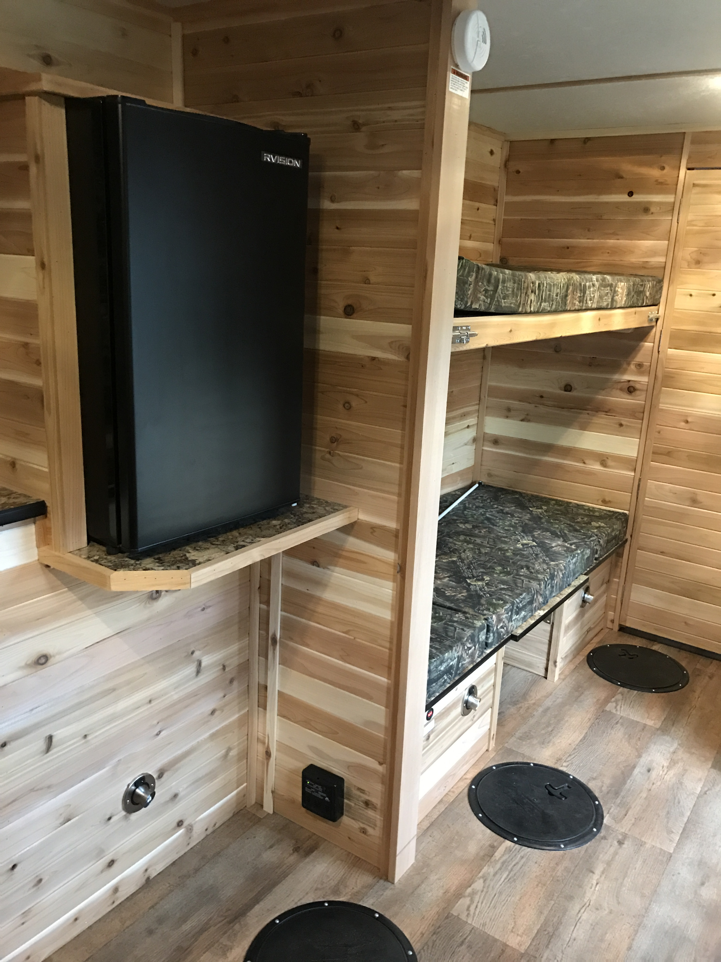 This RV rental ice house features a wood interior, RVISION fridge, bunk beds with camo mattresses, and floor fishing holes.. Ice Castle Fish Houses Rv Edition Standard 2018