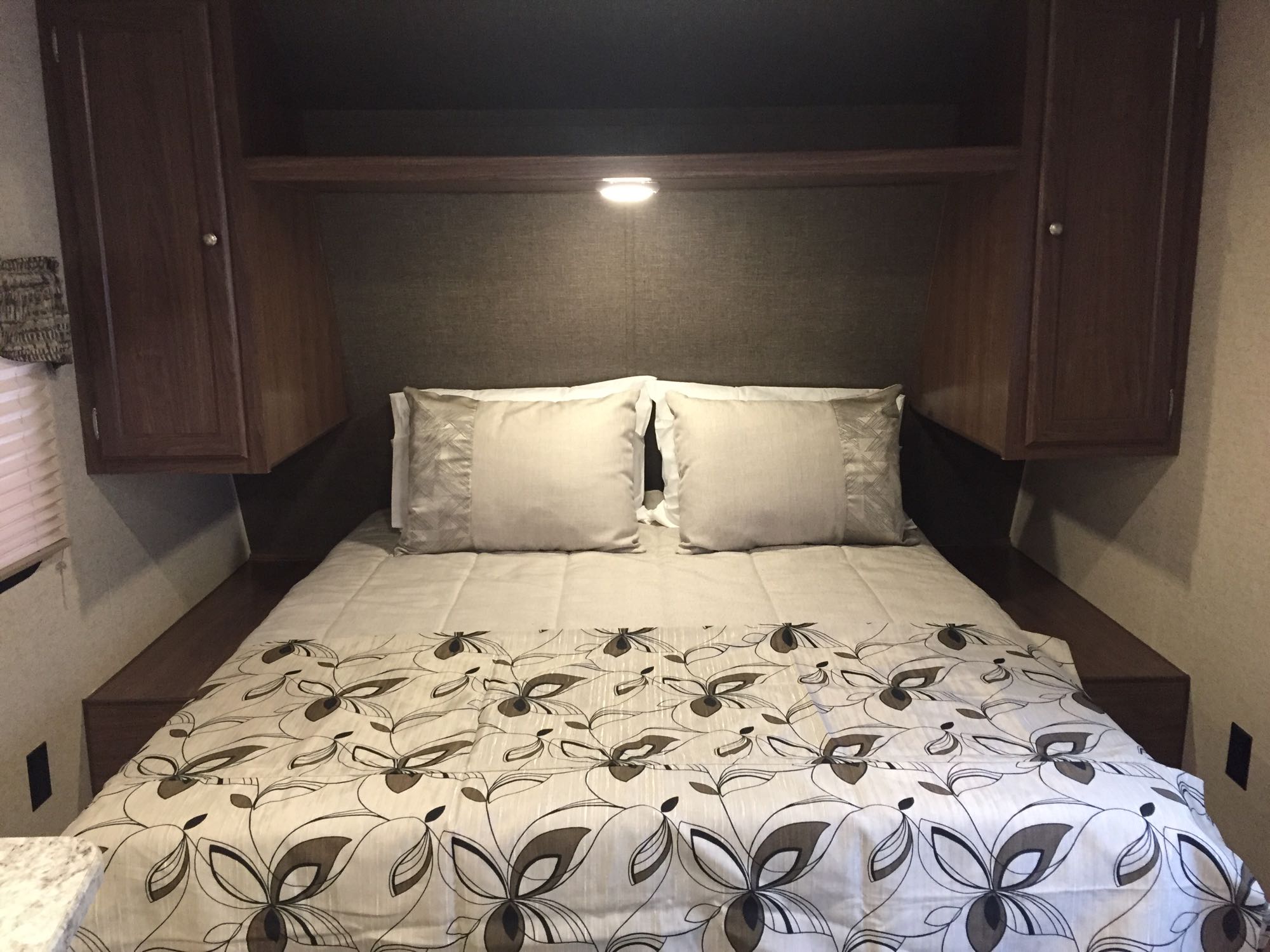 Cozy RV rental bedroom with a comfy bed, overhead cabinets, and a reading light. Perfect for travel.. Heartland Prowler Lynx 2016