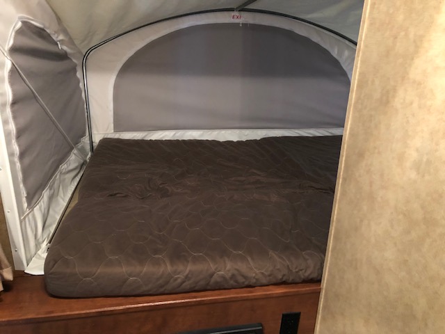 RV rental pop-up camper interior: comfy bed in an expandable sleeping area, ideal for travel trailer adventures.. Dutchmen Kodiak Express 172E 2014