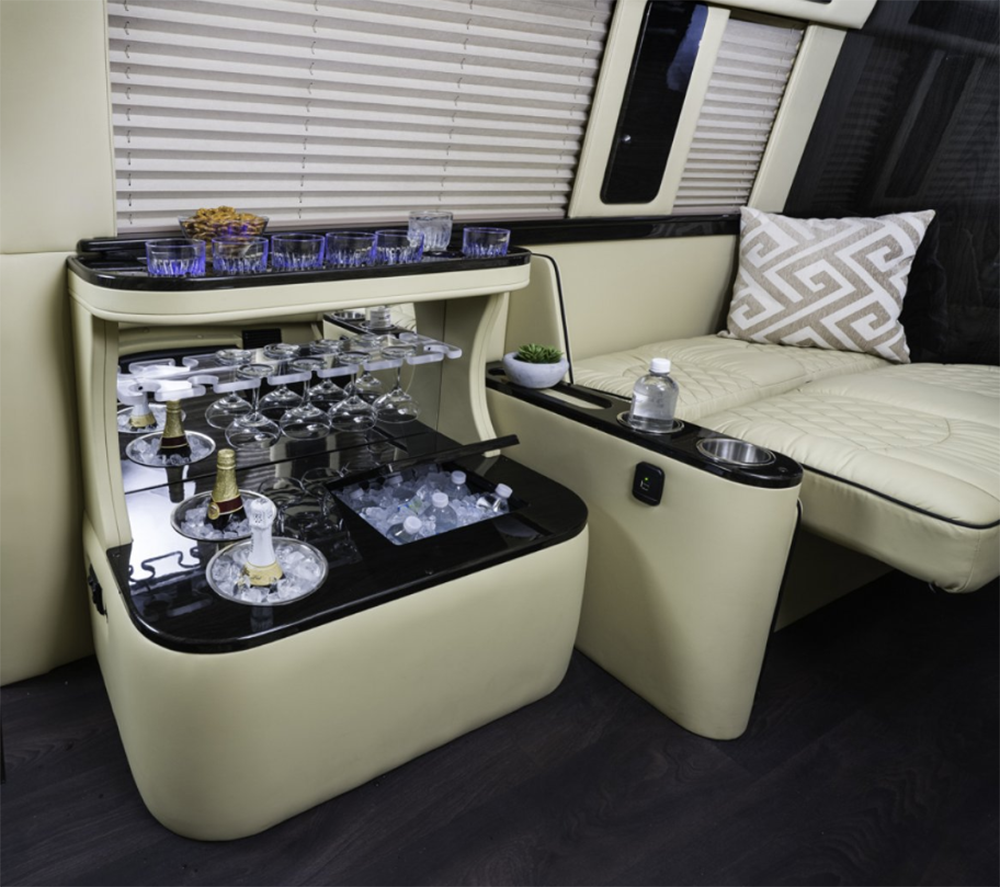 Experience luxury in this RV rental: lavish interior with a built-in bar, chilled drinks, glassware, and plush seating.. Ultimate Toys Entertainer 2020