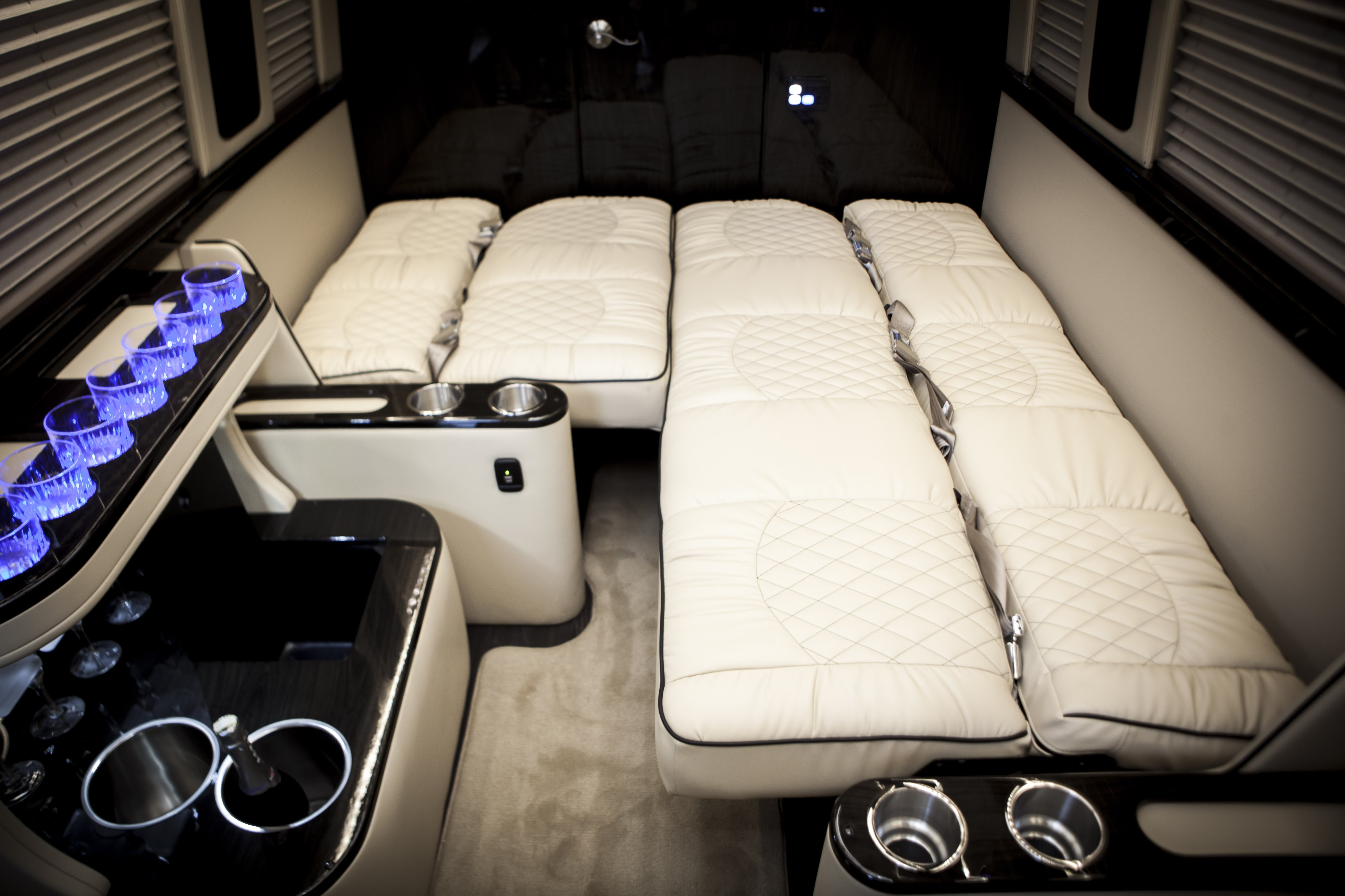 Luxury RV rental interior: plush cream seating/beds, ambient blue lighting, & sleek amenities for comfortable travel.. Ultimate Toys Entertainer 2020