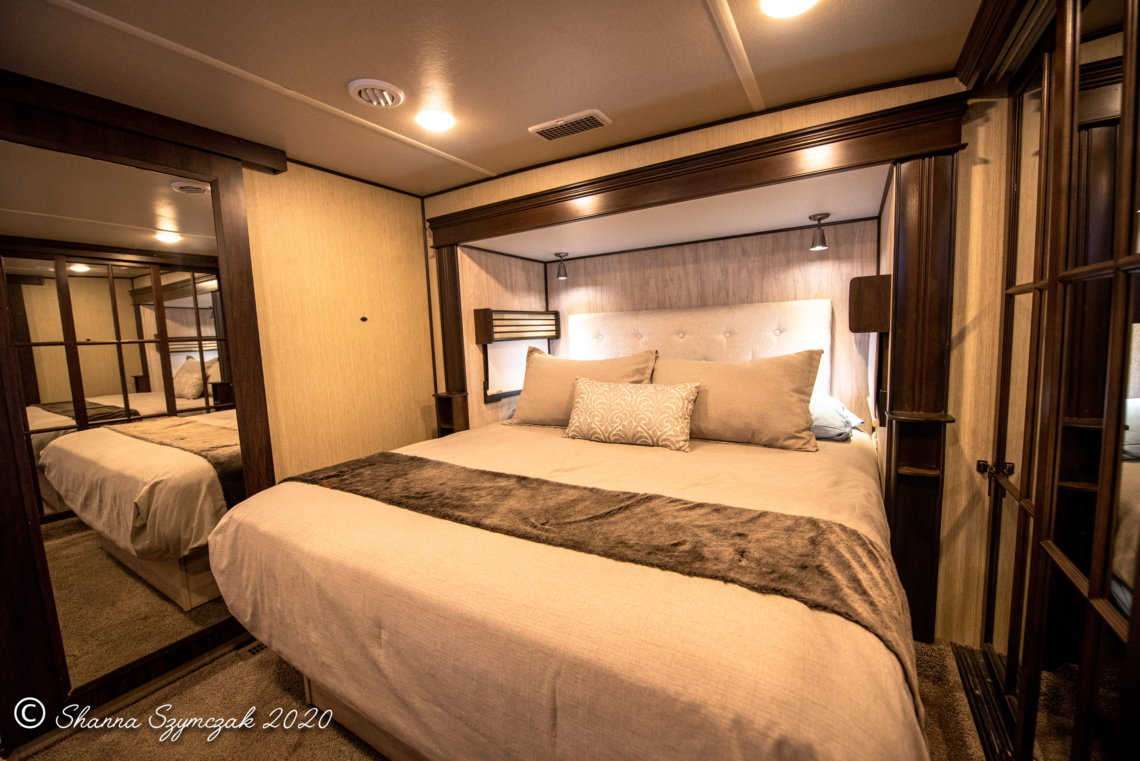 Luxurious RV rental bedroom showcasing a large bed, mirrored closet, and integrated lighting—perfect for travel.. Palomino Columbus 2017