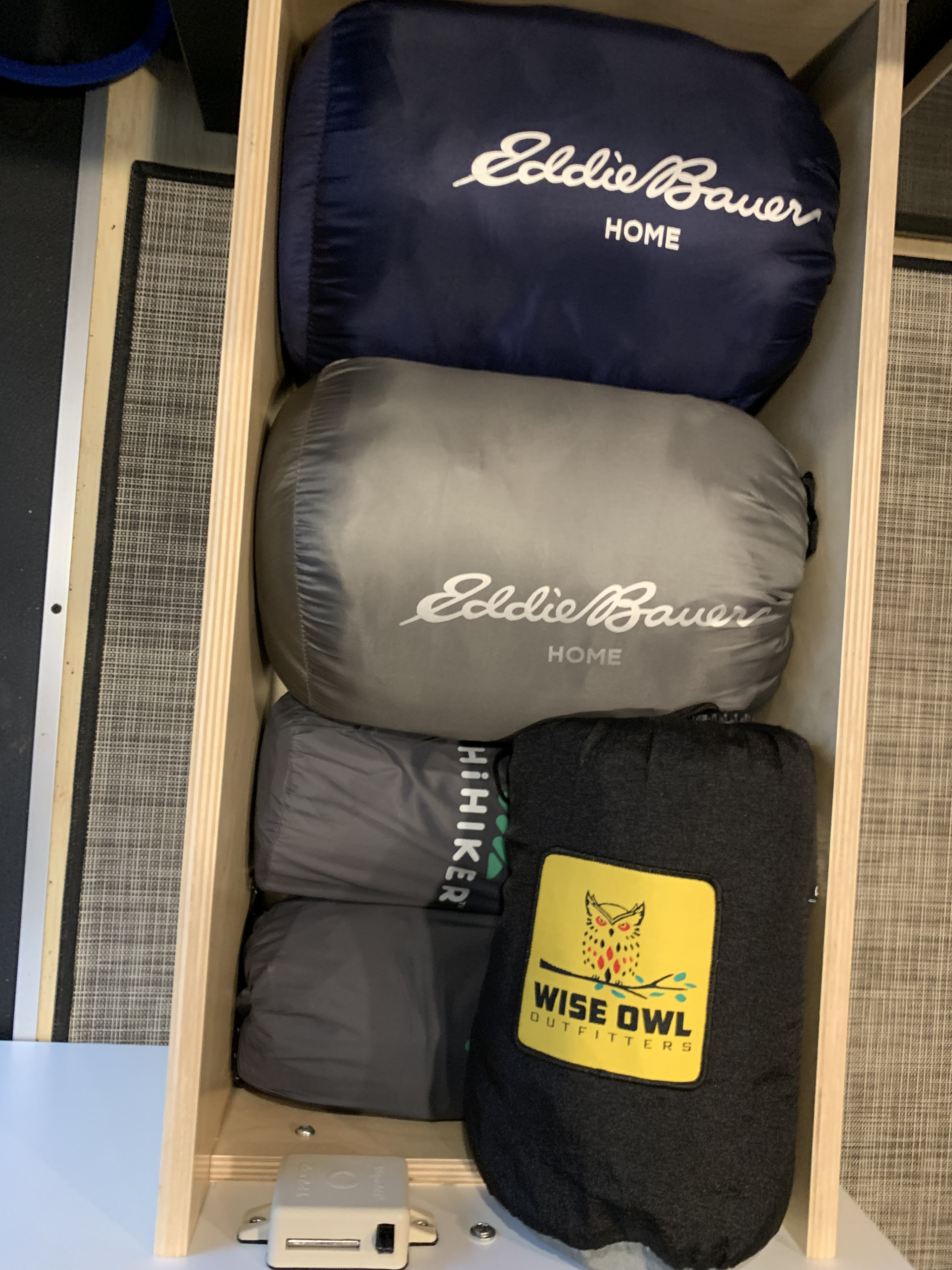 Optimized **RV rental** storage: Packed Eddie Bauer, HiHiker, and Wise Owl Outfitters outdoor gear in a wood drawer.. Nissan NV200 2019