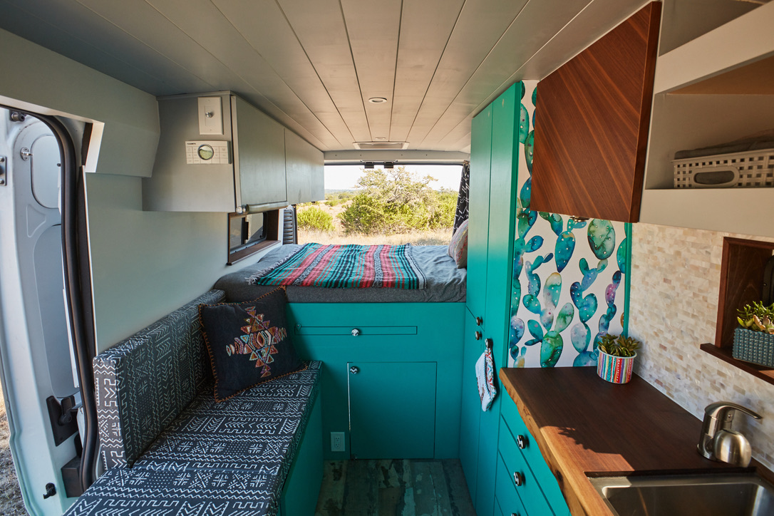 Cozy camper van interior for your next rv rental adventure! Features bed, kitchen, storage, and vibrant decor for van life.. Dodge 2500 Promaster 2019