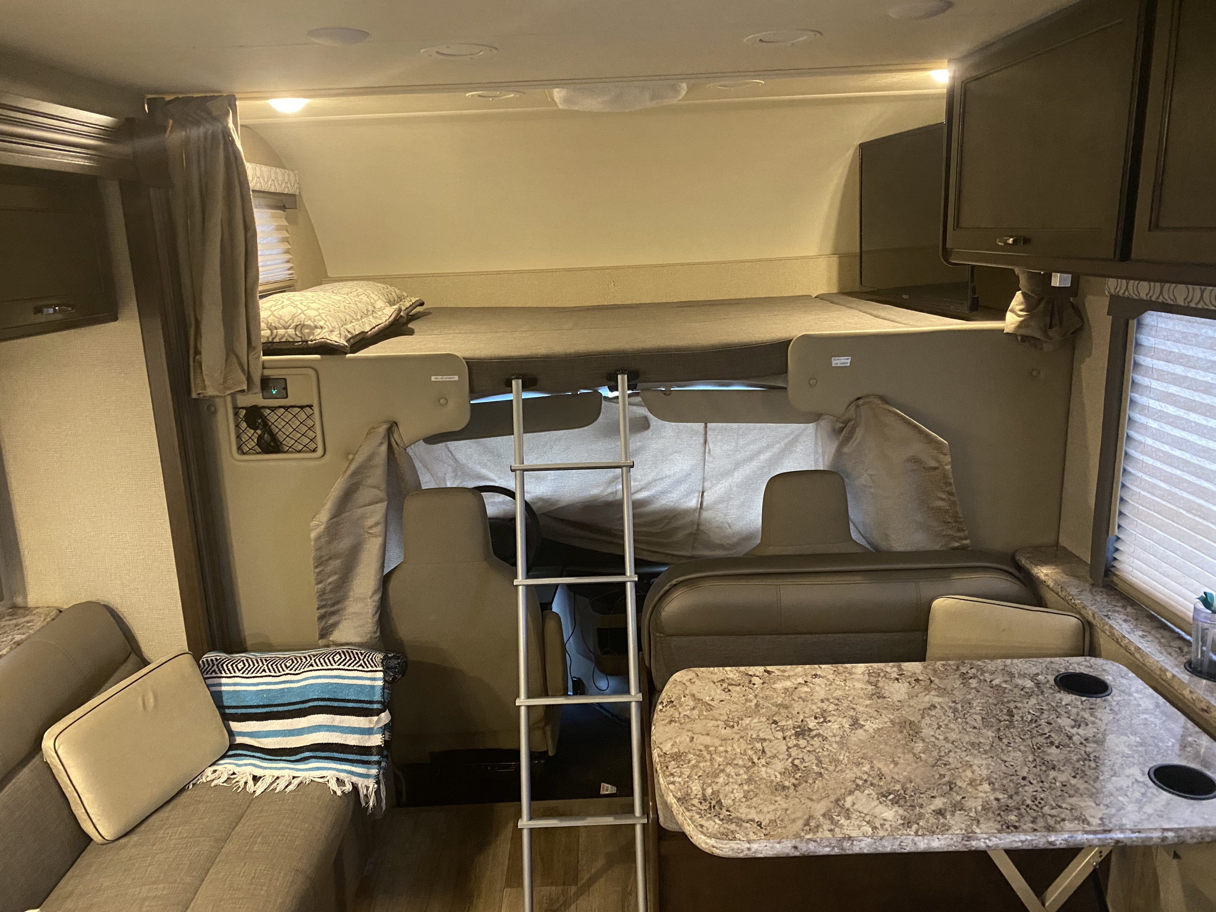 Inside an RV rental, showcasing a spacious bunk bed, convertible dinette, and cozy living area. Perfect for family adventures.. Thor Motor Coach Freedom Elite 2019