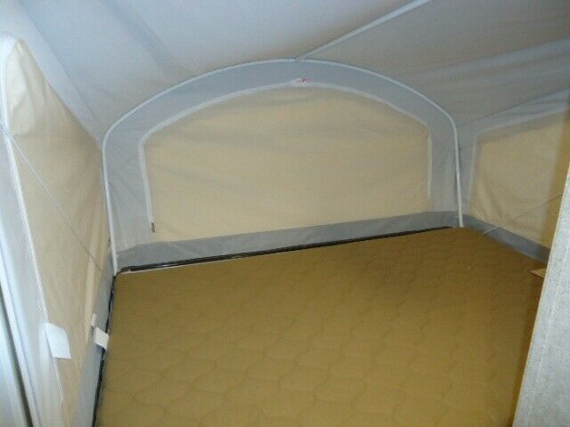 RV rental bunk: A spacious tan mattress in a pop-up camper's fabric-walled sleeping extension.. Coachmen Catalina 2020