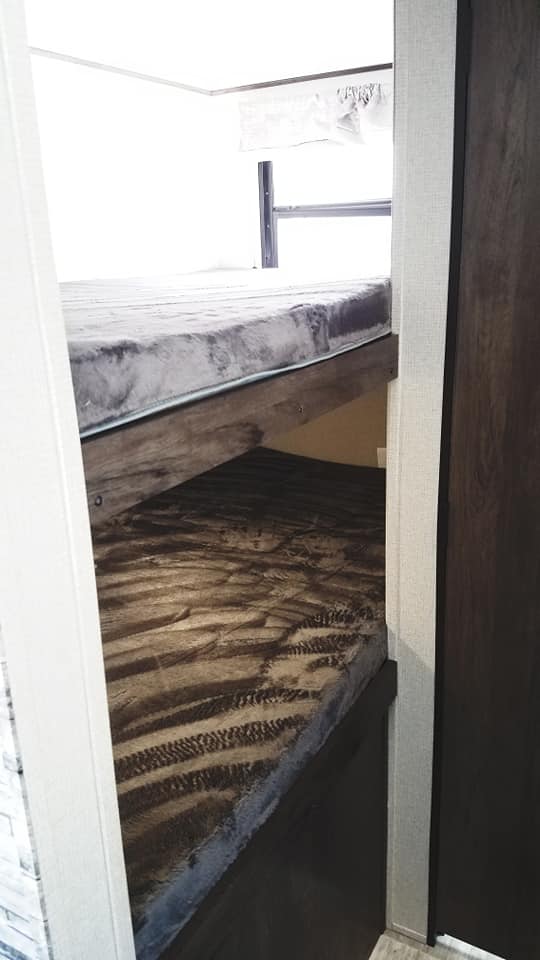 RV rental: Cozy bunk beds in a travel trailer interior. Upper and lower sleeping areas, great for families.. Prime Time Avenger 2020