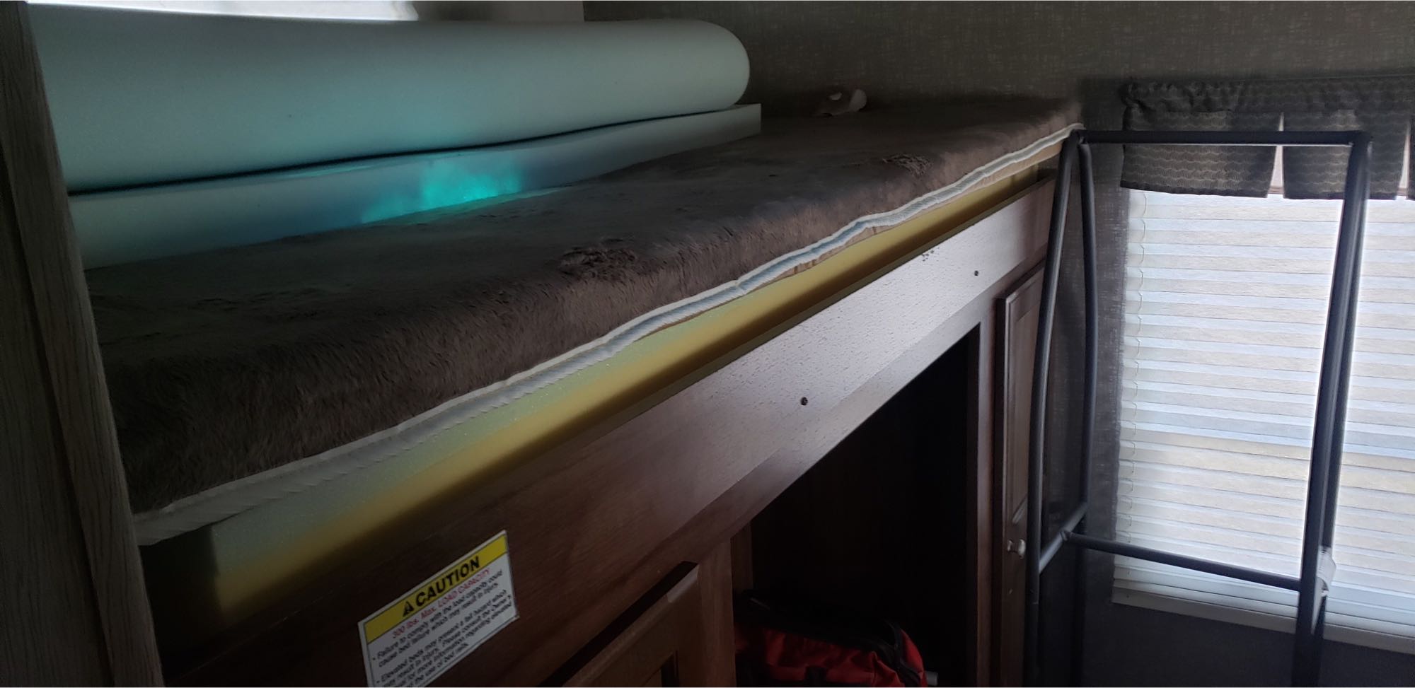 Cozy RV rental bunk beds: the upper with a glow light, lower with a comfy mattress. Includes a safety warning and ladder for access.. Heartland M-3385 2019