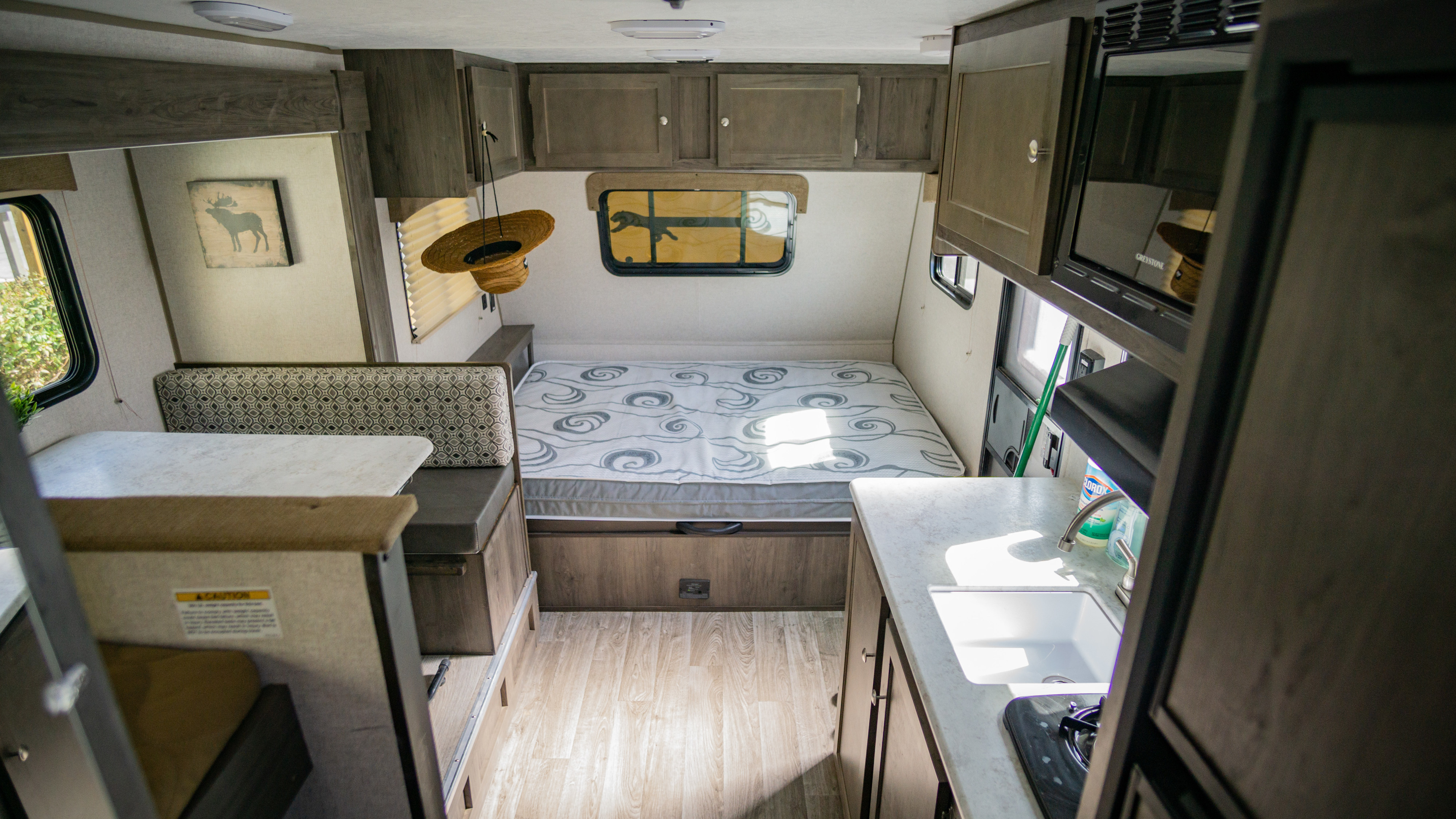 Interior view of an rv rental, showcasing its compact living space with a bed, kitchen, and dinette.. Forest River Clipper Towable 2020