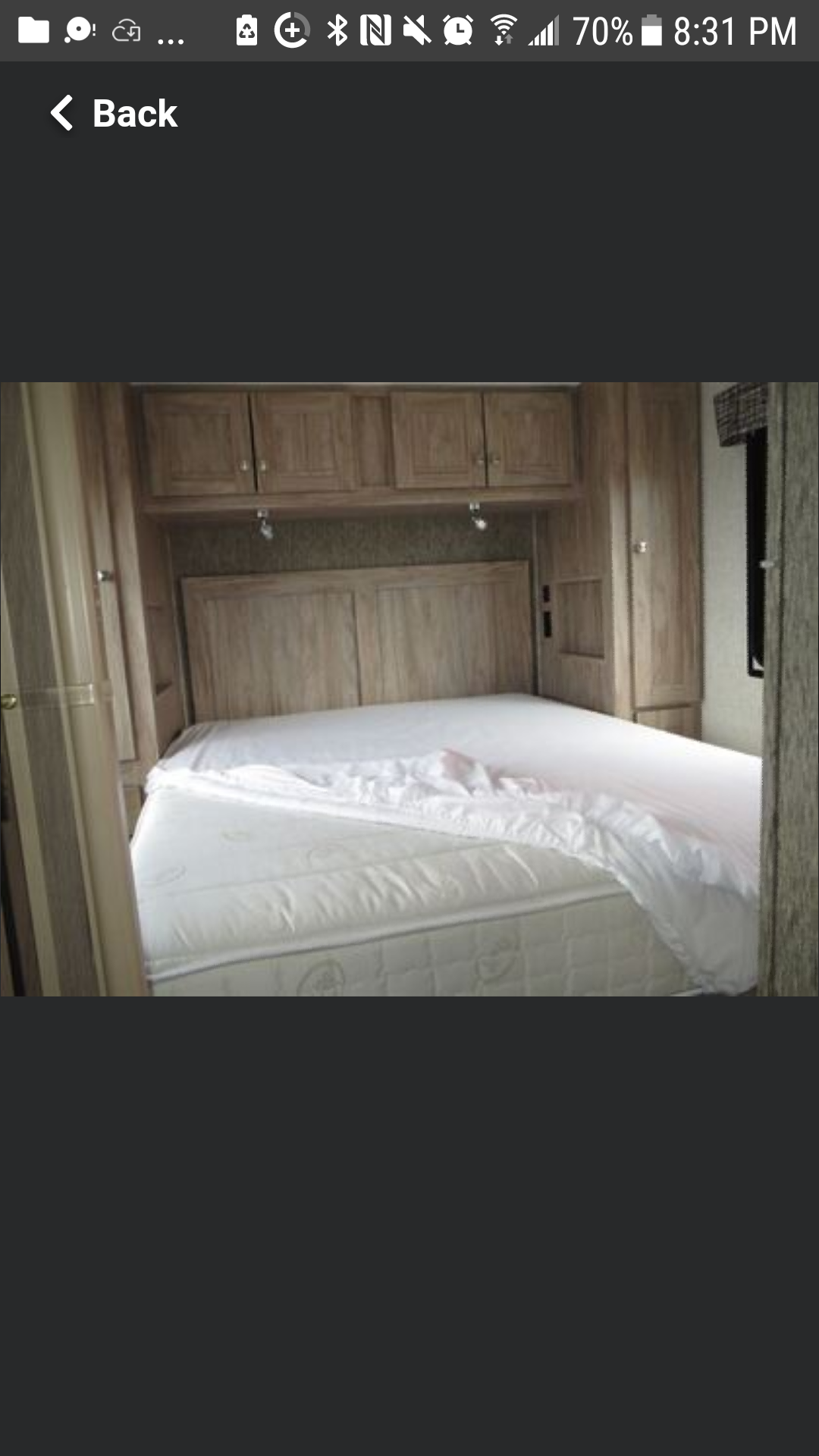 RV rental bedroom: white mattress with sheet, wood headboard & integrated storage cabinets.. Forest River SUNSEEKER 2650S CDW 2018