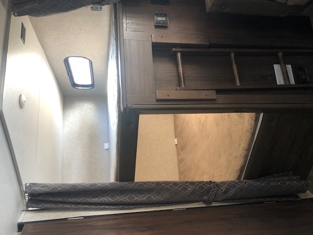 RV rental interior with bunk beds, ladder, and window, providing a cozy sleeping area.. Forest River Cherokee Grey Wolf 2019