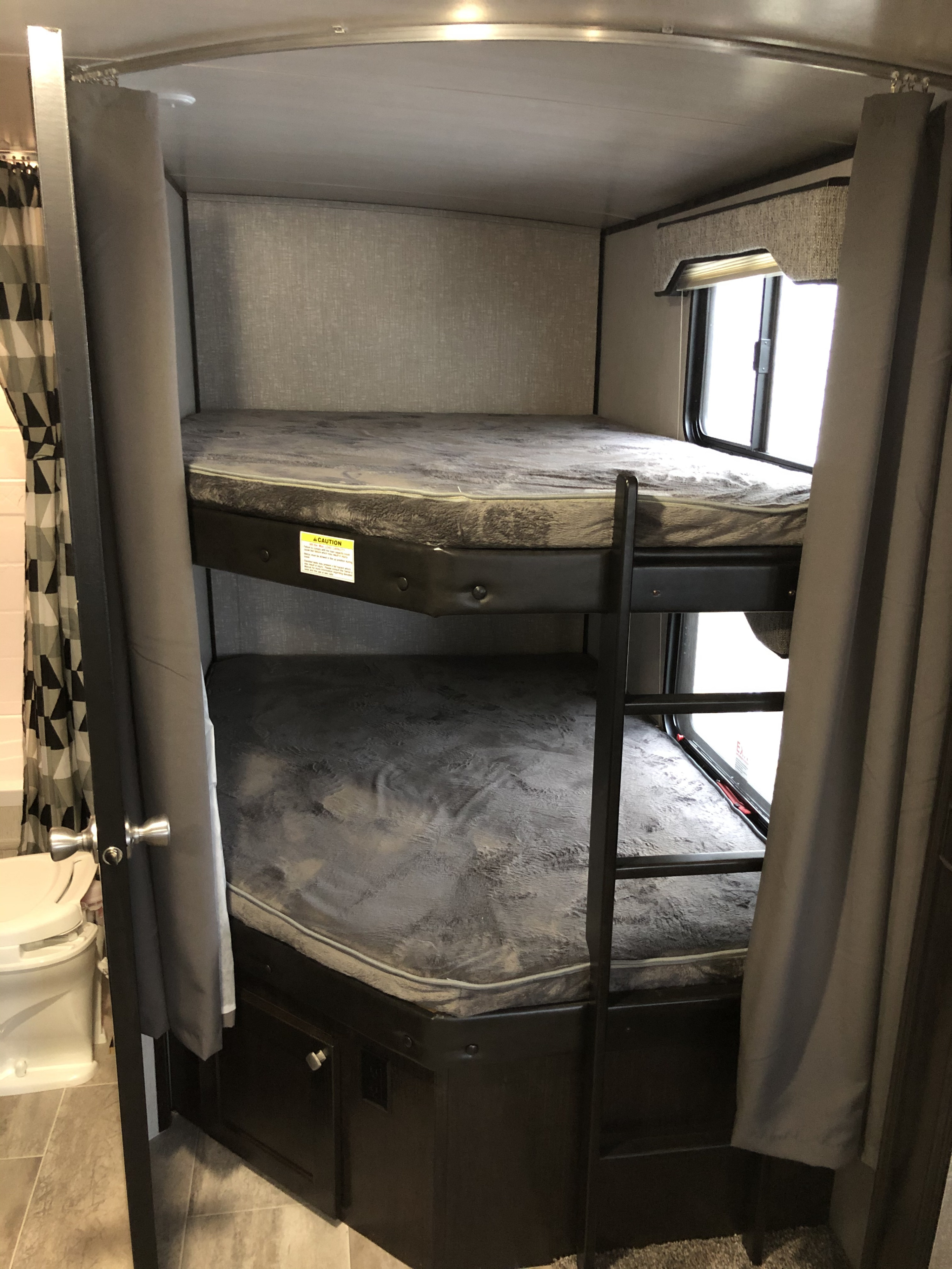 RV rental: Explore a cozy bunk bed sleeping area with ladder and soft mattresses. Perfect for families on the go.. Heartland North Trail 2019