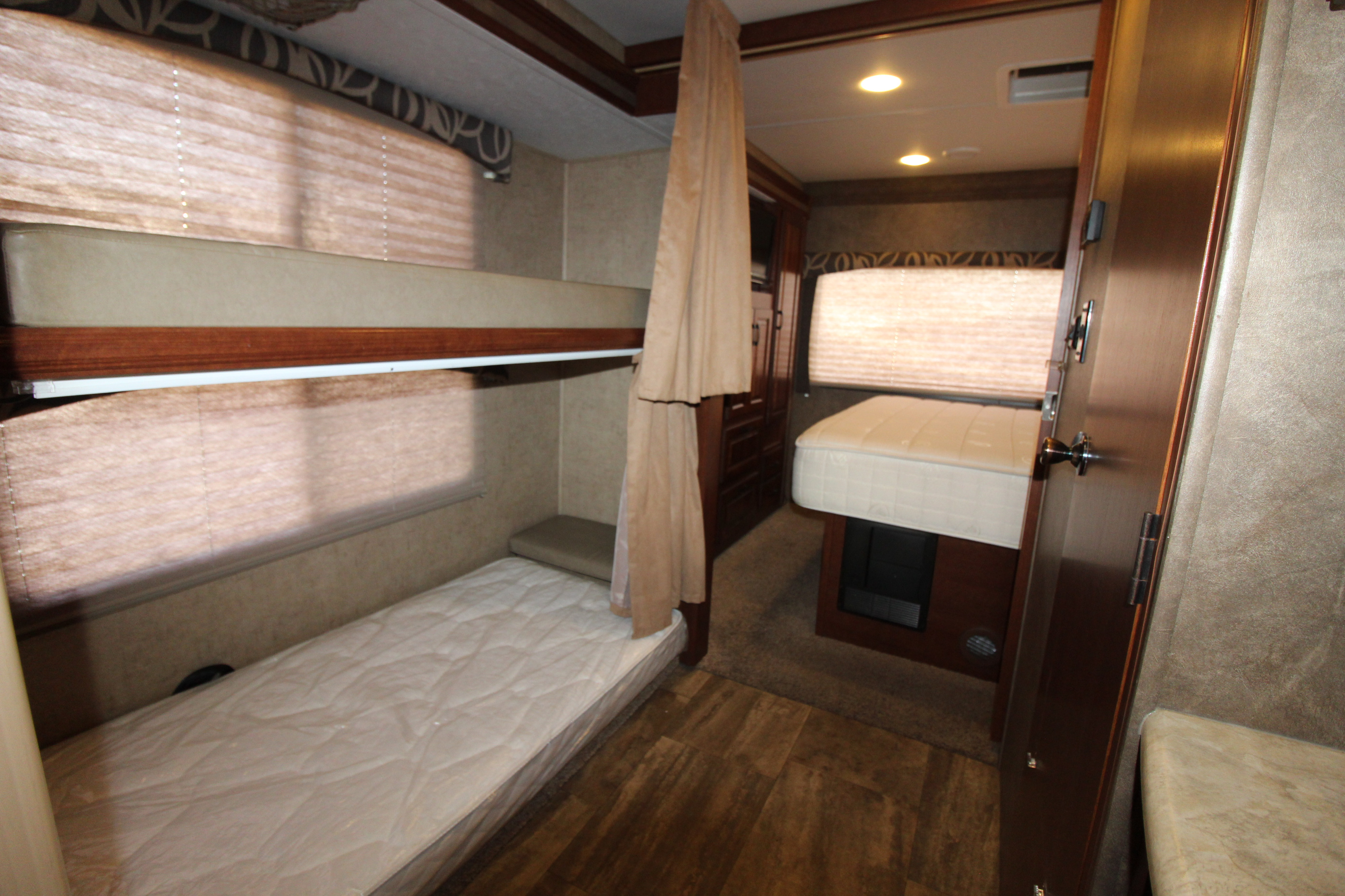 An rv rental interior featuring bunk beds, a master bed, and warm lighting. Ideal for comfortable family sleeping.. Forest River Forester 2016