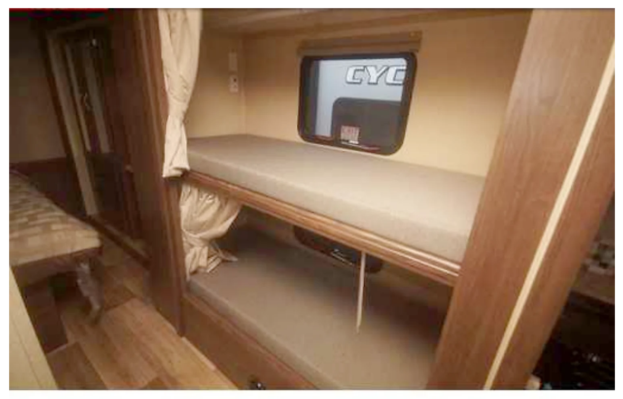 RV rental: Cozy interior with stacked bunk beds, light mattresses, and window for comfortable travel.. Forest River Pursuit 2019
