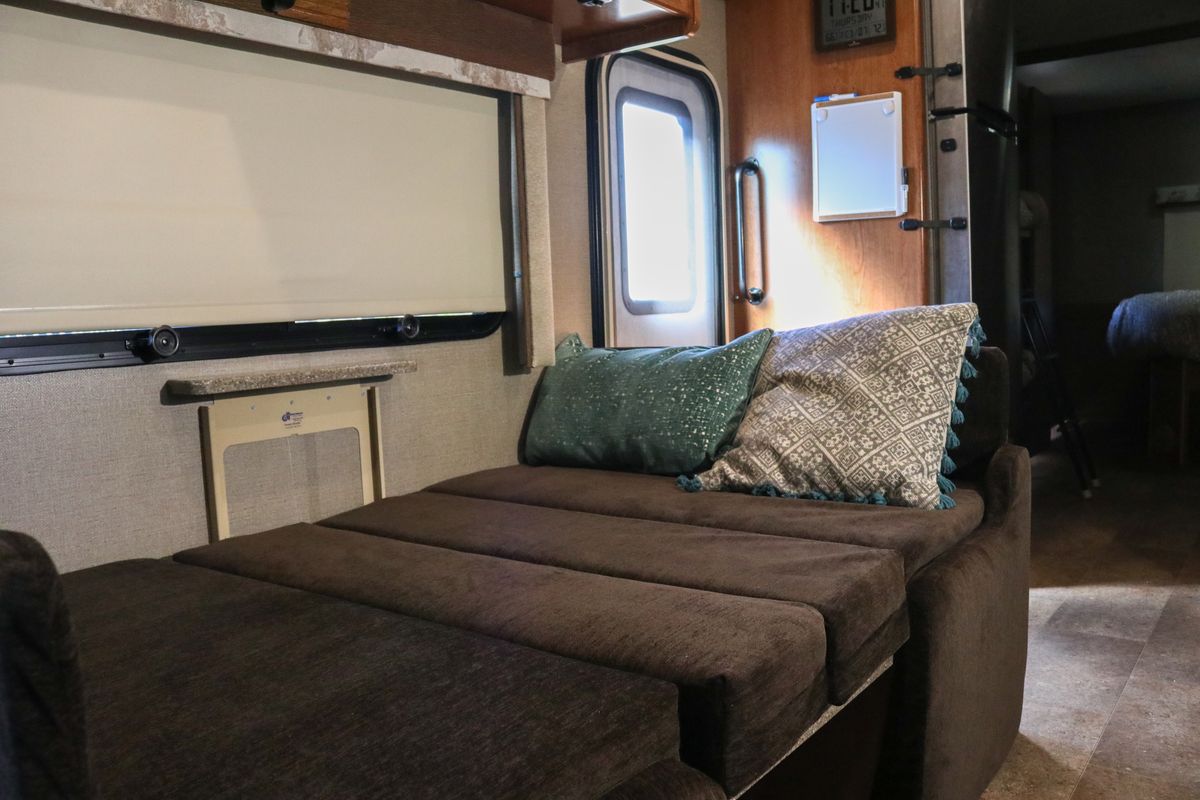 Cozy RV rental interior featuring a convertible sofa, window, and door, offering comfortable living space for travels.. Holiday Rambler Other 2017