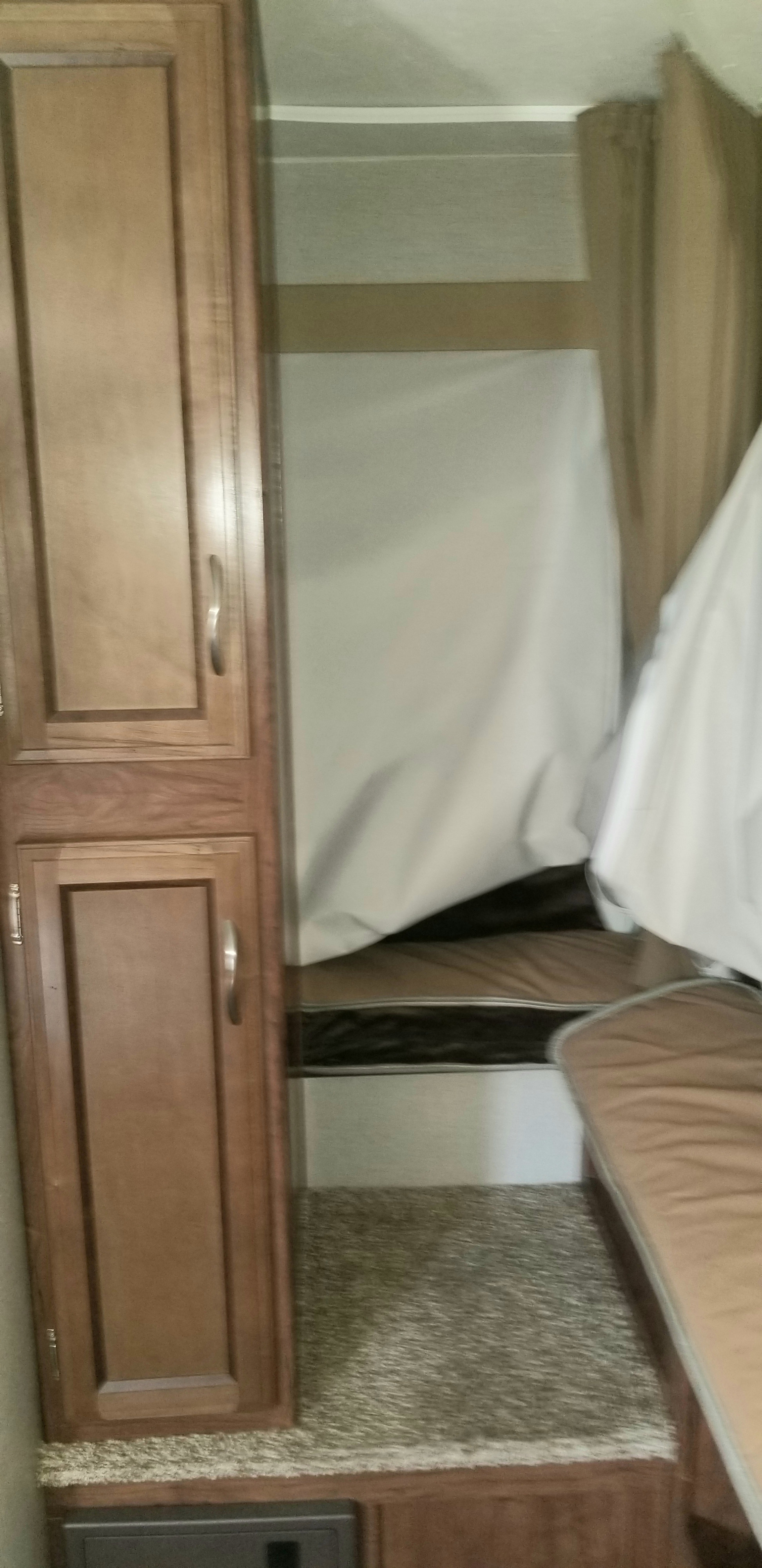 RV rental interior: cozy bunk beds, a wooden cabinet, and plush carpet create a comfortable space.. Coachmen Freedom Express 2016