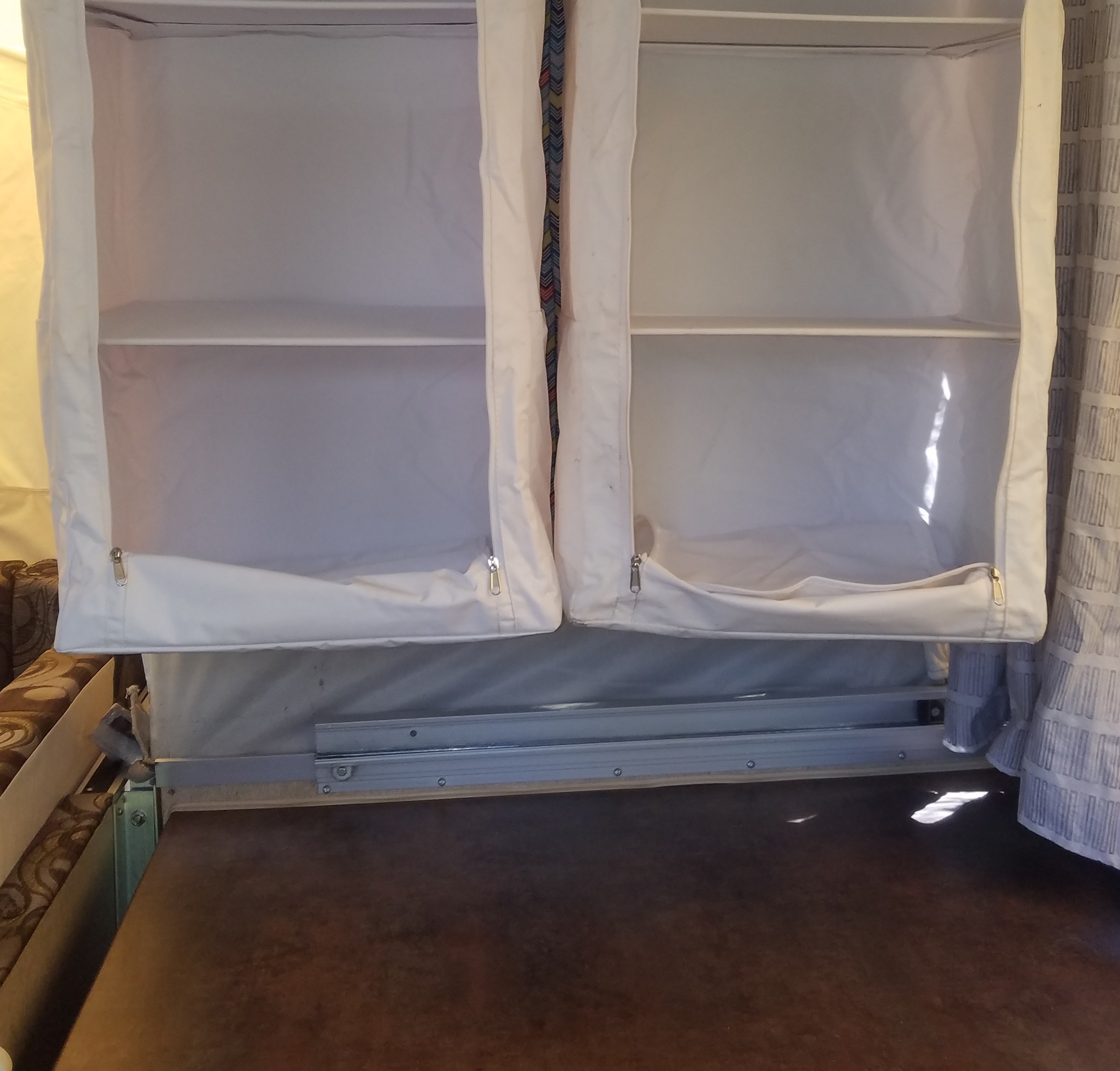 Two soft-sided, multi-compartment storage shelves visible inside an RV rental, offering space-saving organization.. Forest River Rockwood Premier 2013