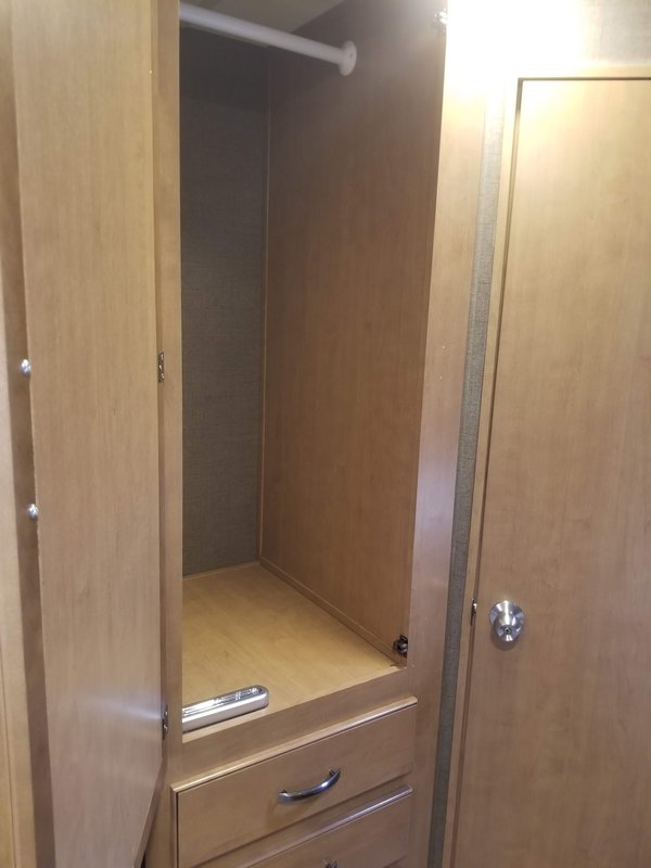 RV rental wardrobe: wood finish, hanging rod, shelf, and pull-out drawers. Ample storage for your travel needs.. Thor Chateau 2017