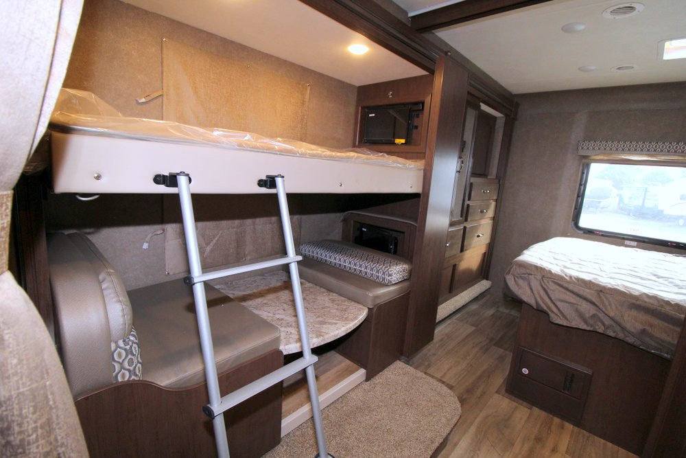 RV rental interior featuring bunk beds, a main bed, and compact living space, perfect for family comfort on the road.. Thor Motor Coach Freedom Elite 30FE 2020