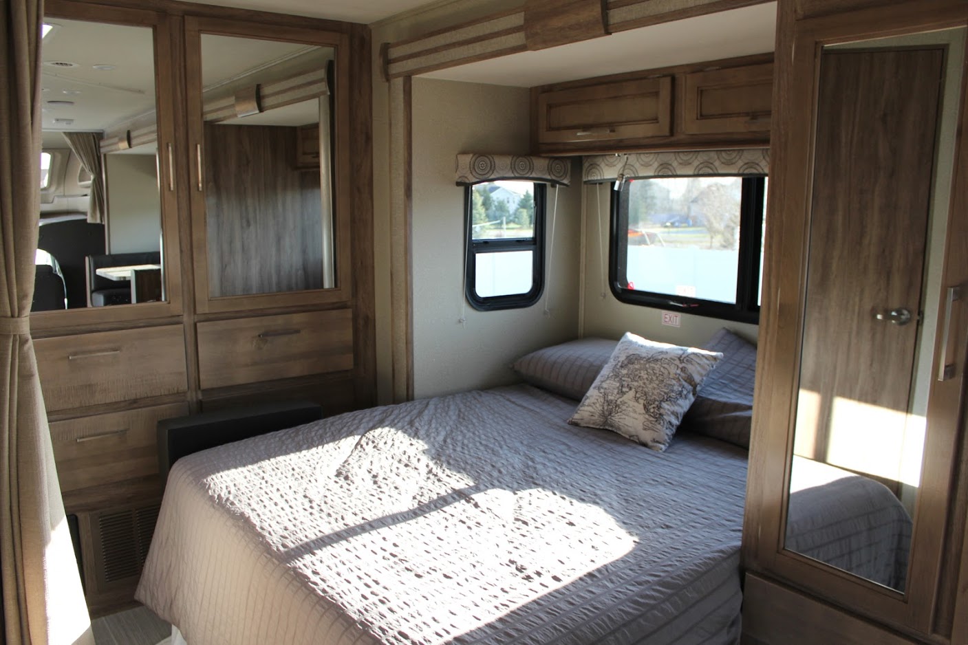 Bright RV rental bedroom: features a comfortable bed, mirrored wardrobe, and windows with scenic outdoor views.. Entegra Coach Odyssey 24B 2020