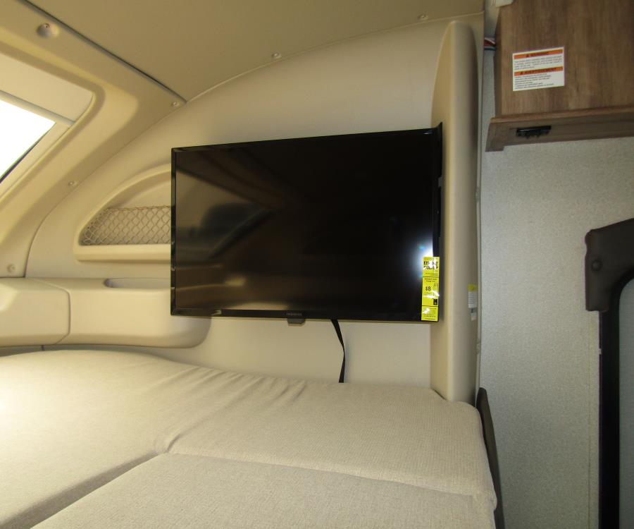 RV rental with a wall-mounted TV above the sleeping area, offering compact comfort & entertainment.. Entegra Coach Odyssey 26D 2021