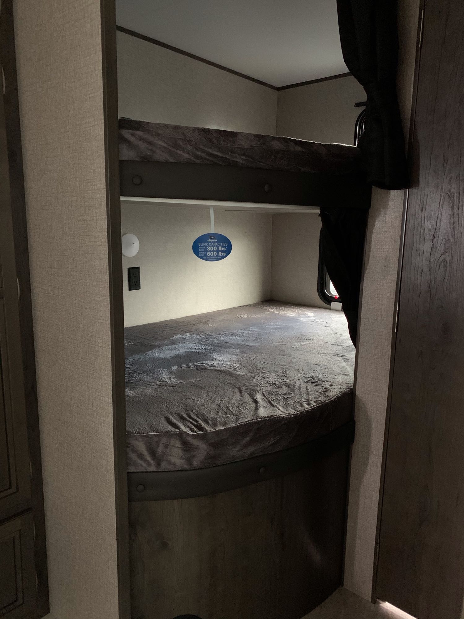 RV rental bunk beds, upper and lower. A sign shows 300 lbs (single) and 600 lbs (double) capacity for these sleeping areas.. Jayco Other 2021