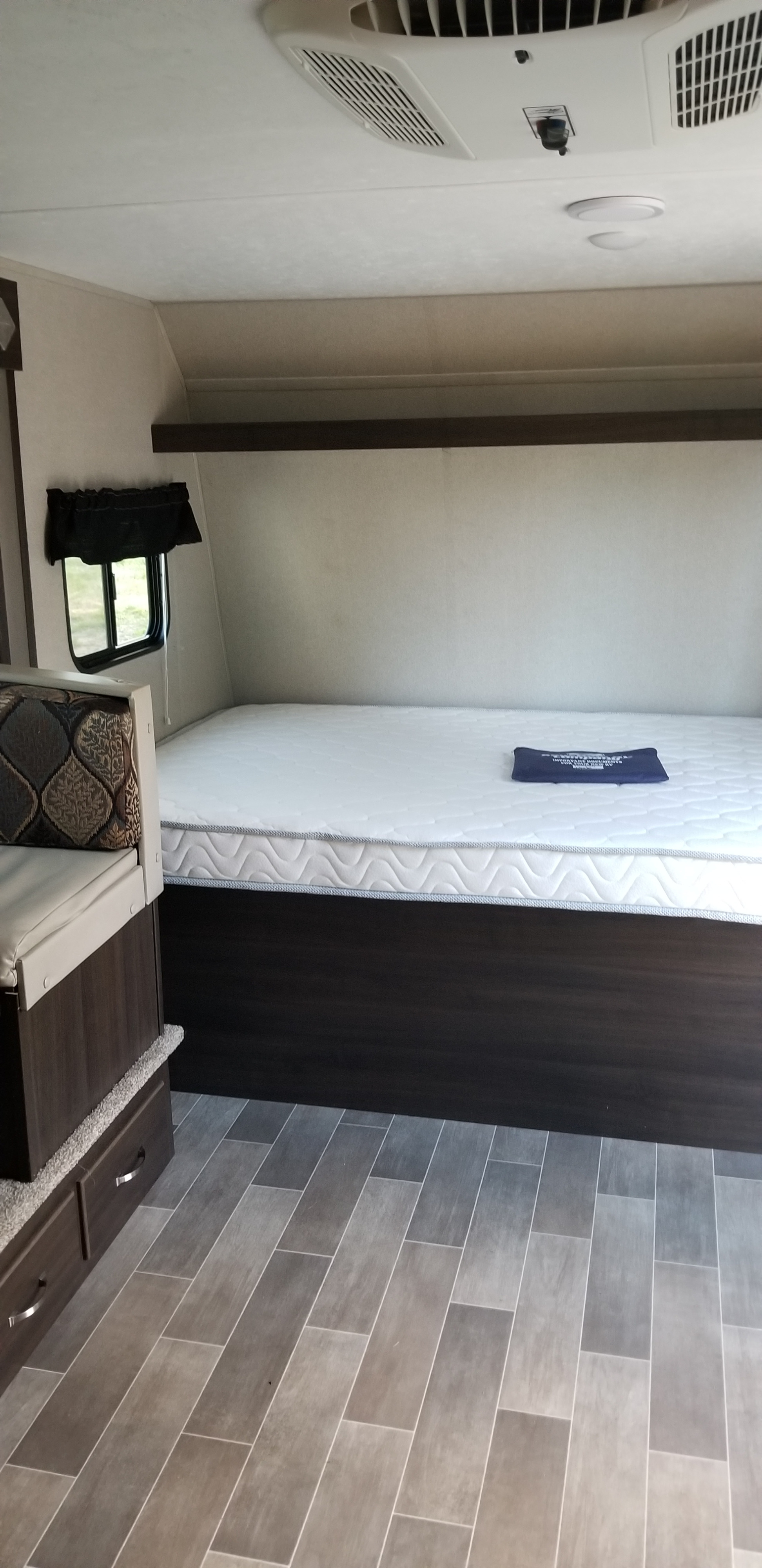 Comfortable RV rental: interior features a bed, dinette seating, window, and modern tiled floor.. Keystone Springdale 2019