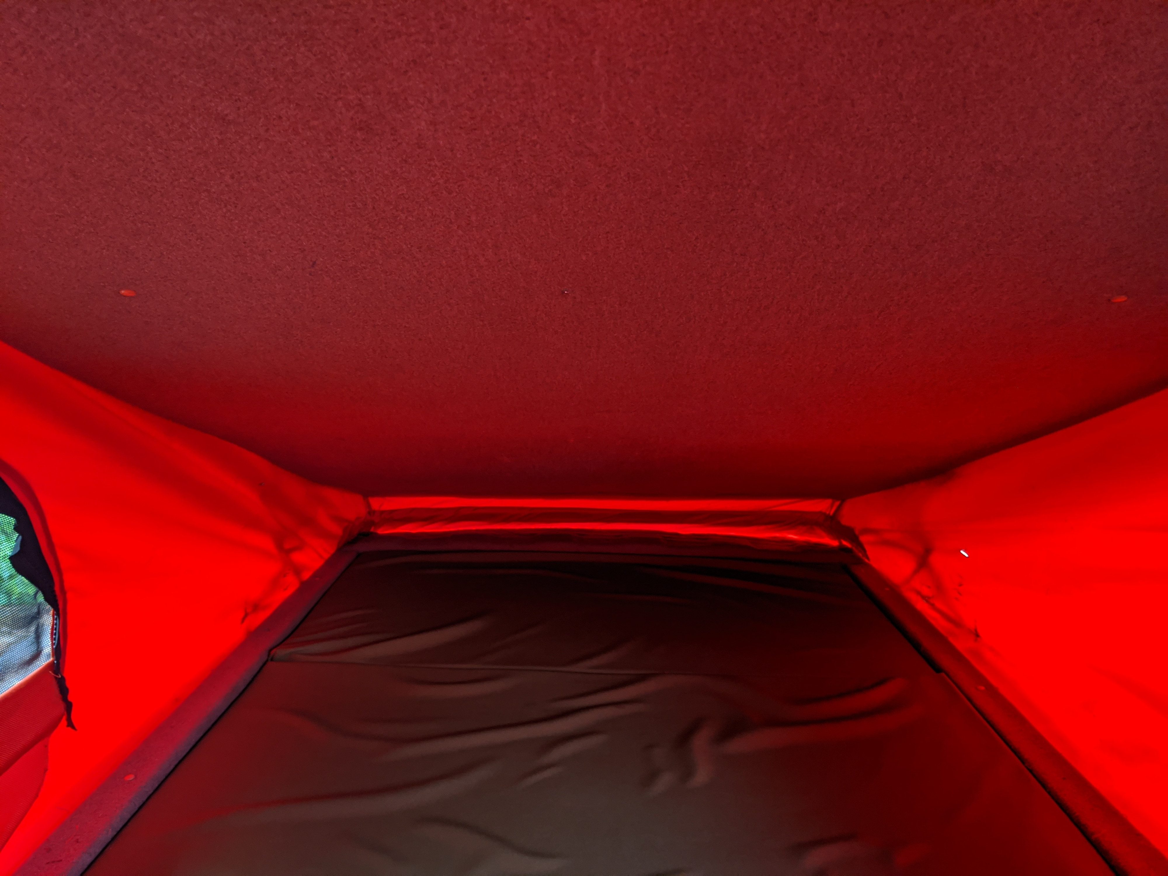 Cozy red-lit pop-top sleeping area of an RV rental, offering a unique camping experience.. Volkswagen Other 2007