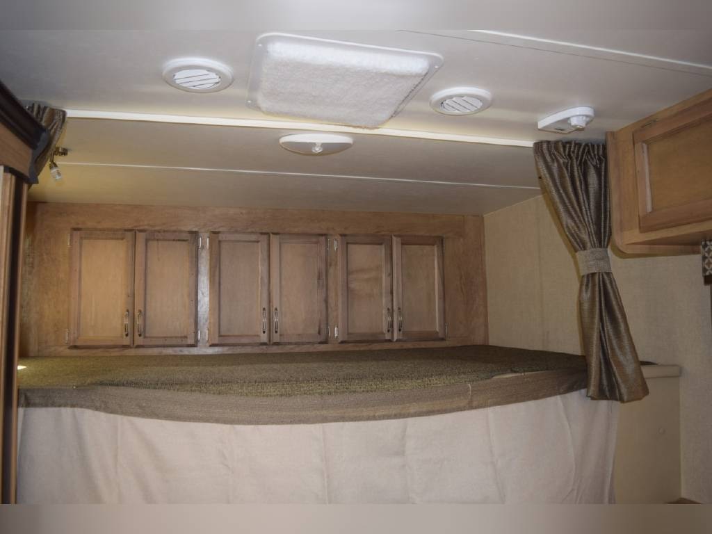 This RV rental features a comfortable bunk bed, ample overhead storage cabinets, and ceiling vents.. Gulf Stream Conquest 2018