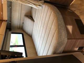 Inside this RV rental: A cozy sleeping area with a curved bed & large window for scenic views.. Winnebago View 2018