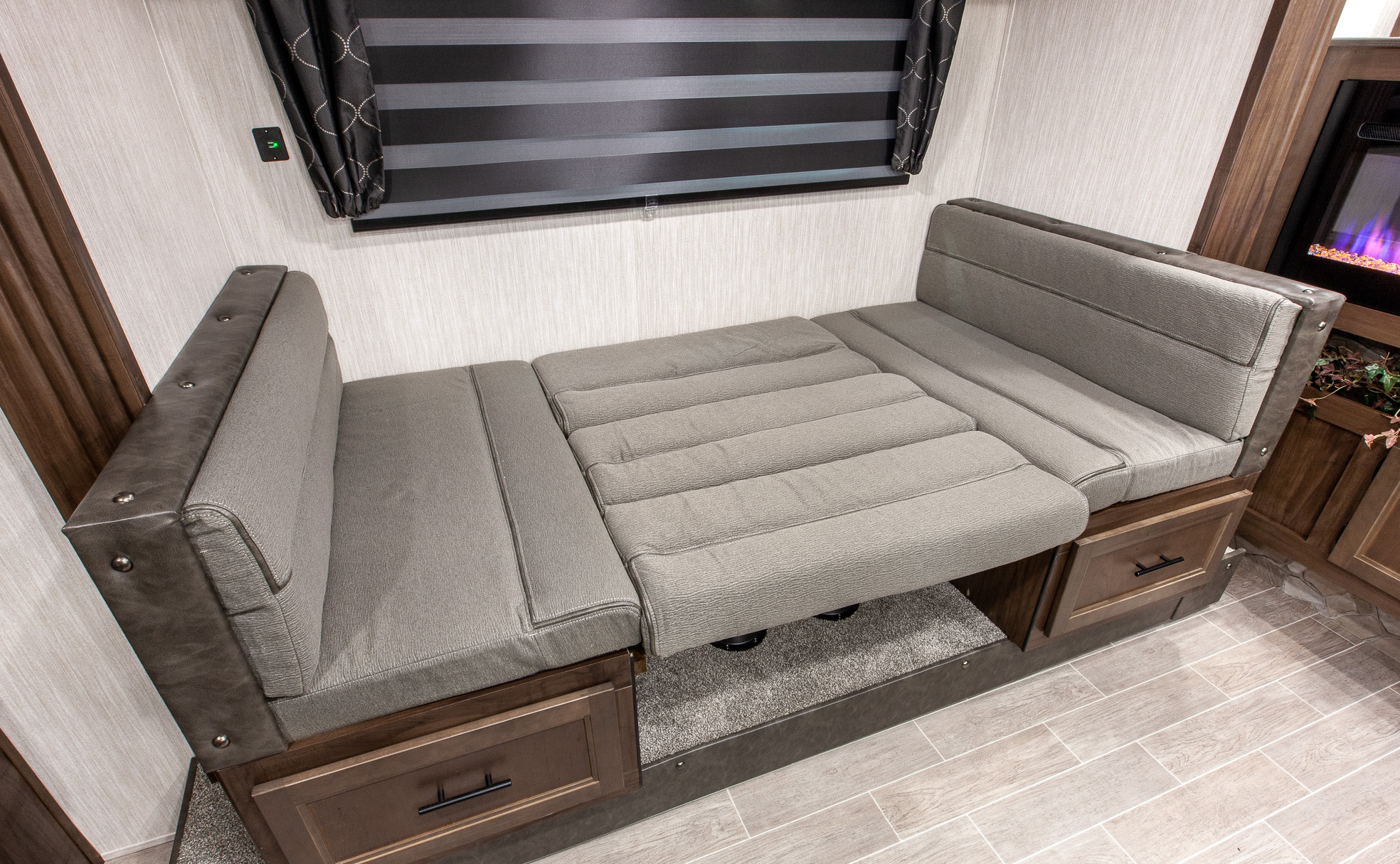 Experience RV rental comfort: A convertible dinette with storage is shown halfway transformed into a cozy bed.. Forest River Cherokee Grey Wolf 2020