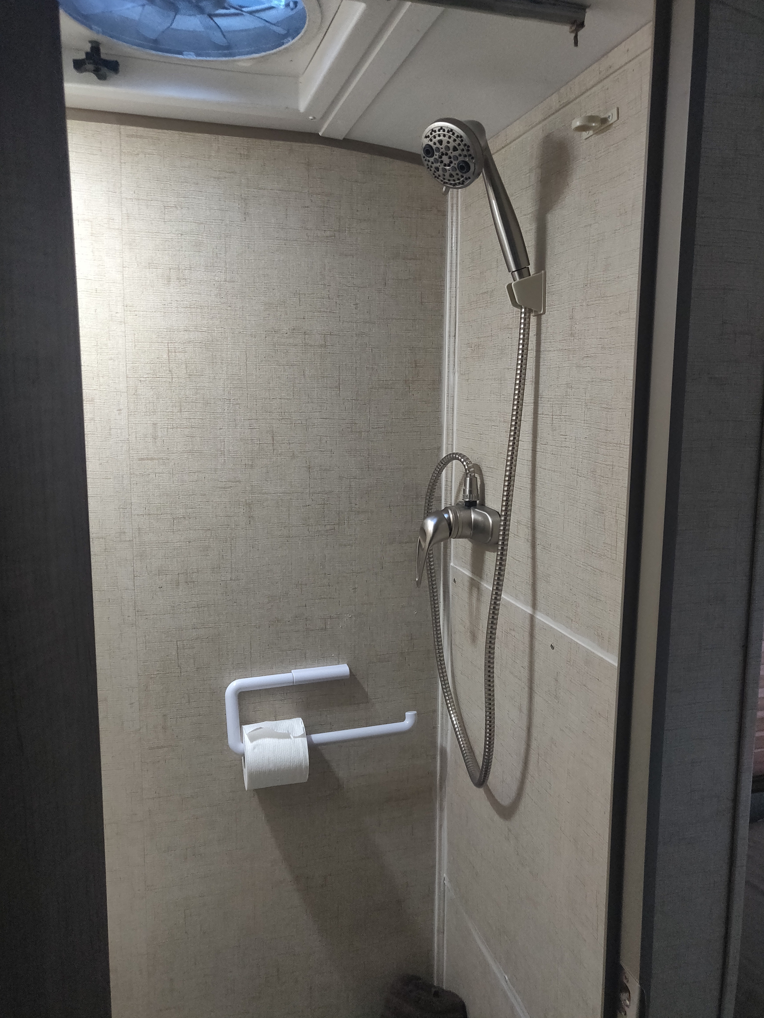 Compact RV rental shower featuring a handheld showerhead and a toilet paper holder conveniently inside the stall.. Forest River R-Pod 178 2015
