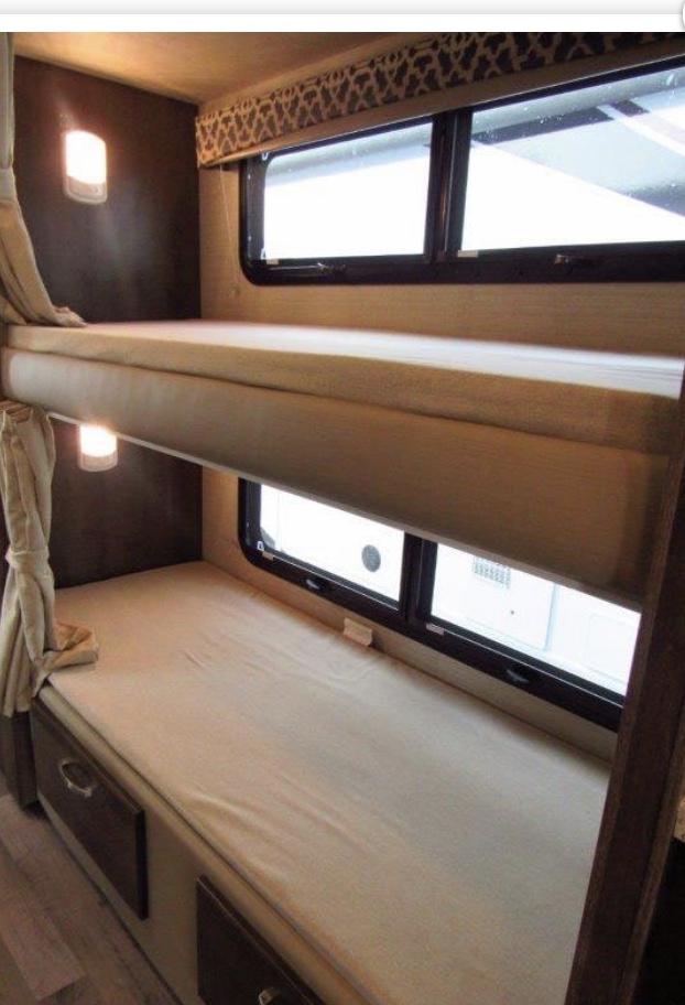 Cozy RV rental bunk beds with individual lights and windows, perfect for family travel and comfortable accommodation.. Jayco Redhawk 2020