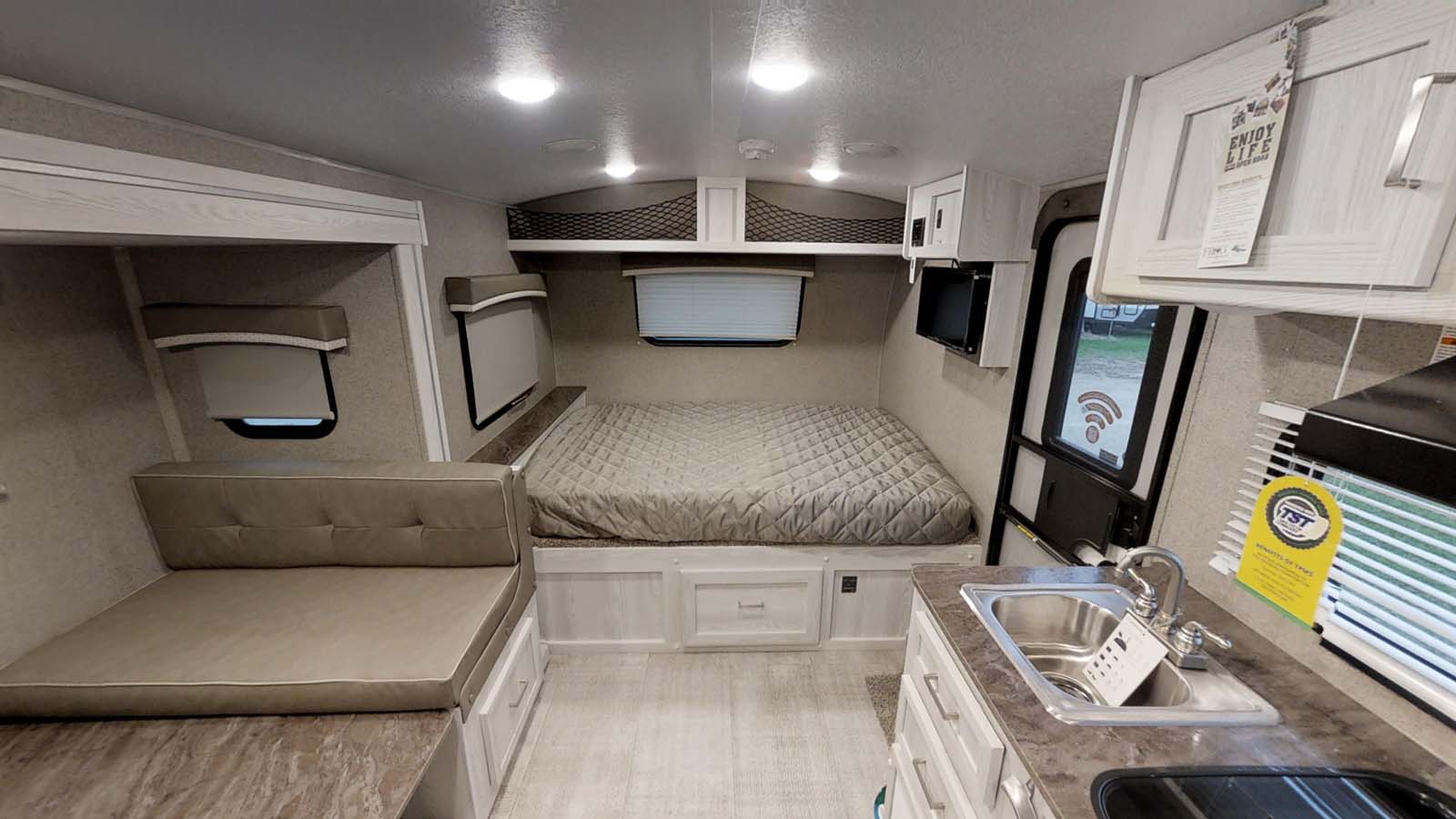 Inside a bright RV rental: features a comfortable bed, compact kitchen, and lounge area for travel.. Forest River Rockwood Geo Pro 2021