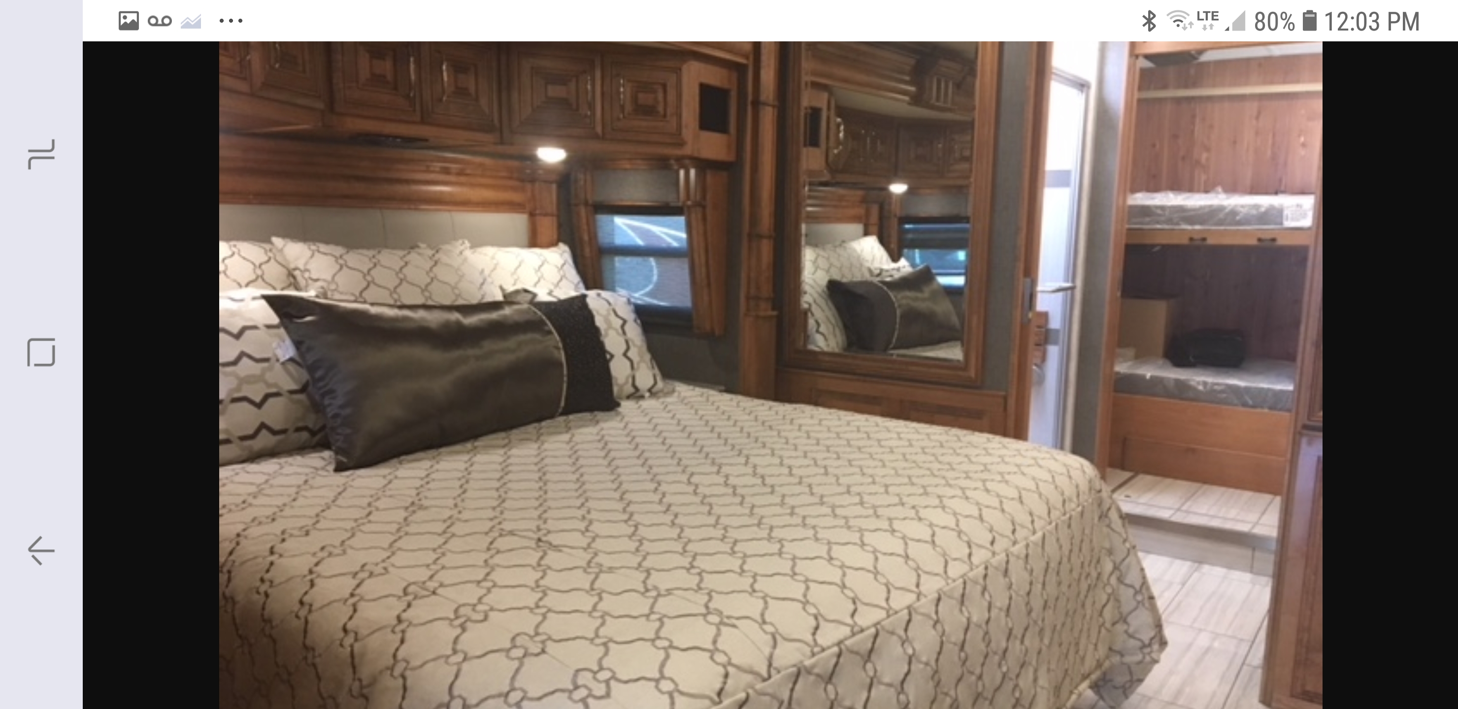 Luxurious RV rental interior featuring a master bed with ornate cabinetry and bunk beds, offering comfort for your journey.. American Coach 42B 2019