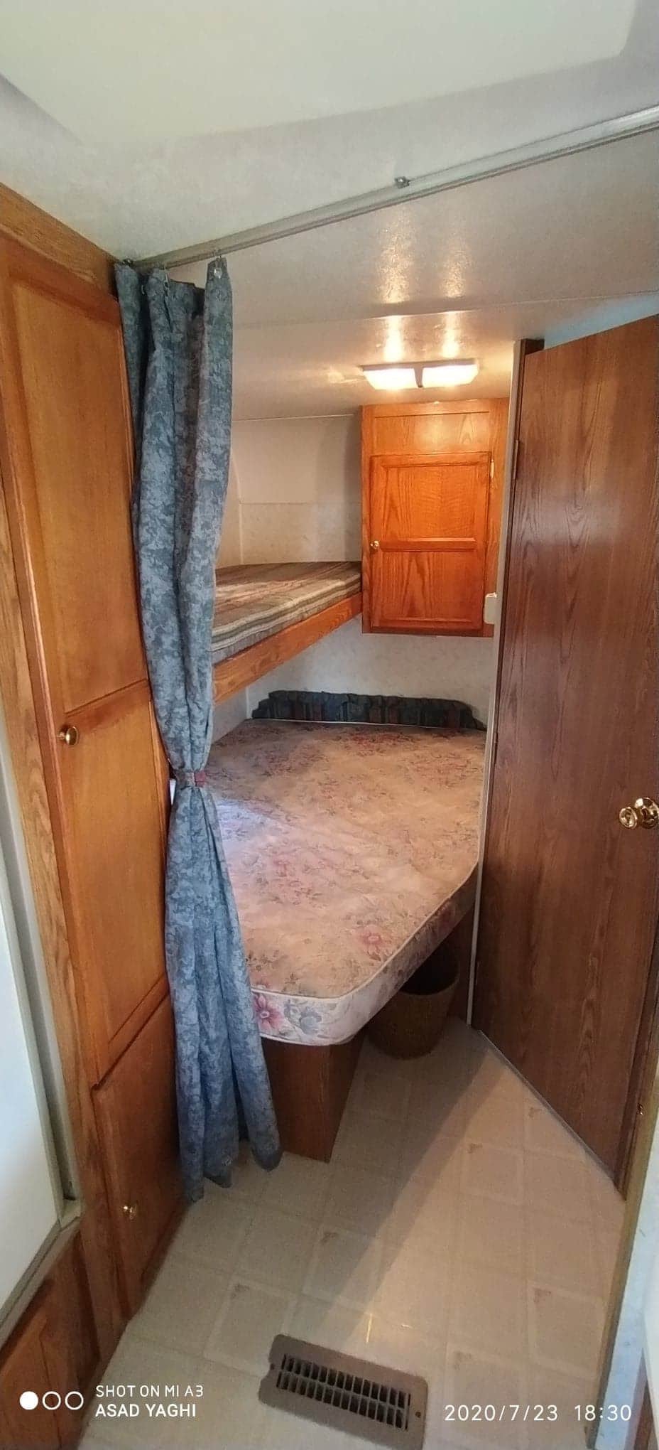 Cozy RV rental interior featuring bunk beds, with a privacy curtain and wood cabinetry.. R-Vision Other 1999