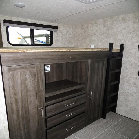 RV rental: Built-in bunk bed with ladder and integrated storage. Features cabinets, shelves, and drawers. Functional RV interior.. Open Range Open Range 2018