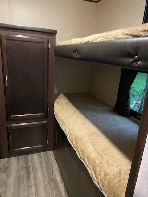 RV rental: Compact bunk beds and storage cabinet, featuring cozy bedding and wood-look floor.. Jayco Other 2018