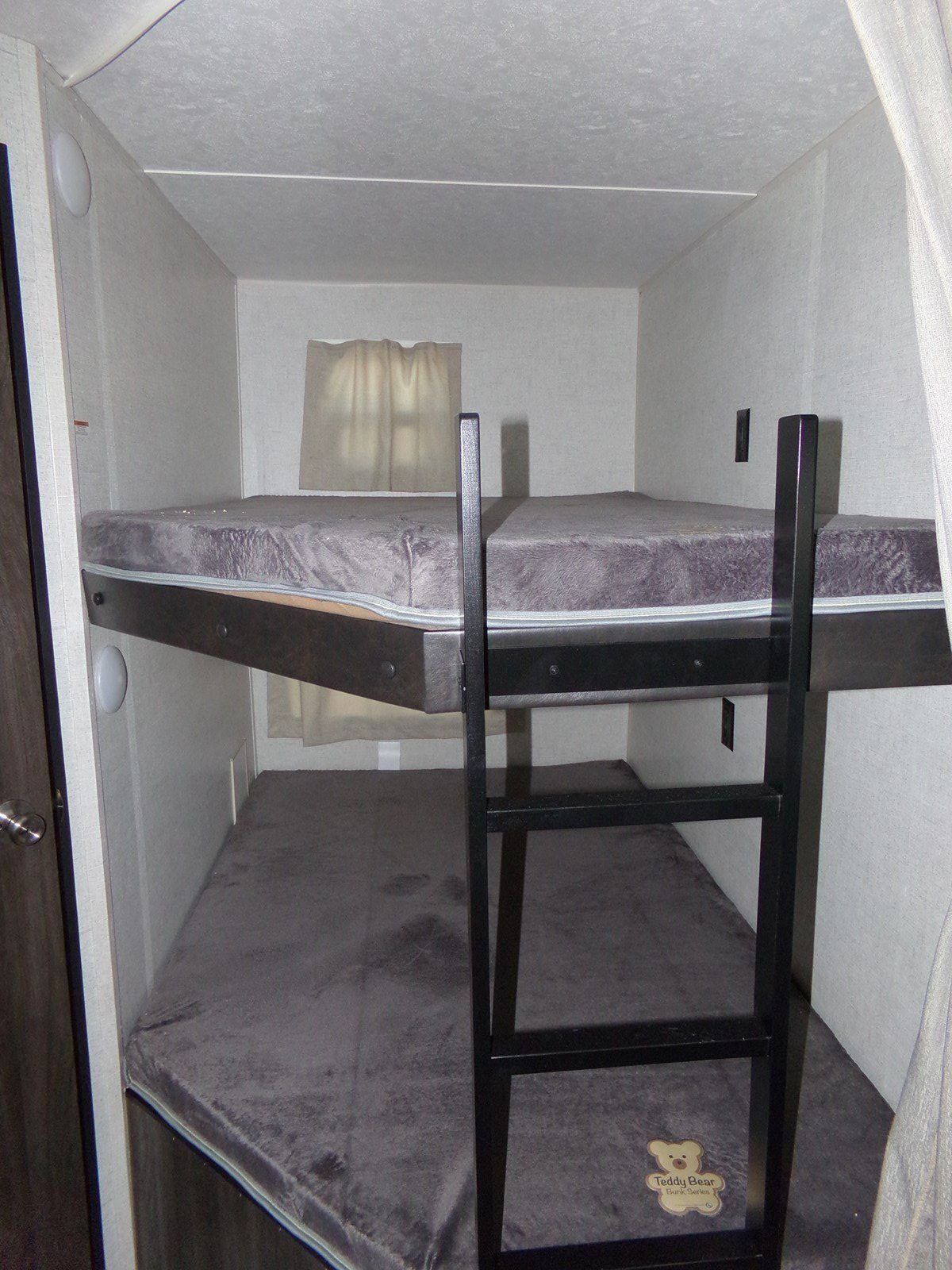 RV rental: Compact sleeping area with stacked bunk beds, grey mattresses, and a black ladder for easy access.. Open Range Open Range 2020
