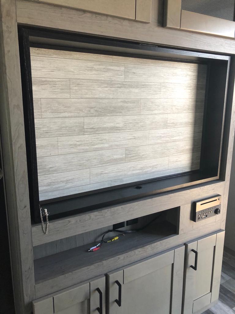 This RV rental features a built-in entertainment center with a large TV opening, media player, & lower storage cabinets.. Heartland Other 2021
