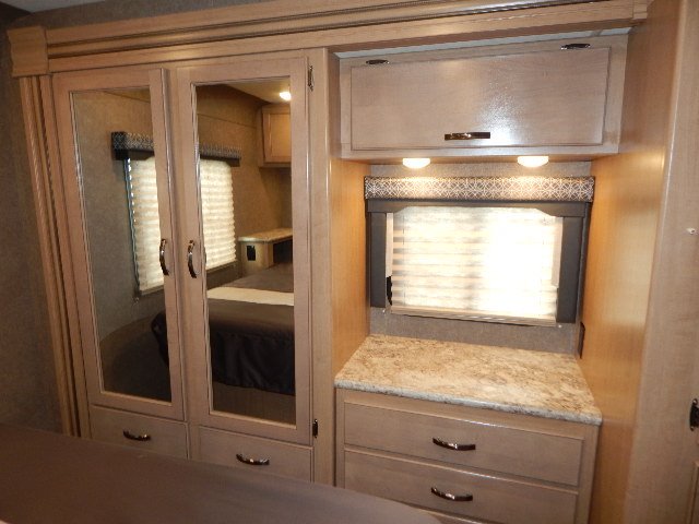 RV rental bedroom interior with mirrored wardrobe, dresser, overhead cabinet, and window blinds.. Other Other 2020