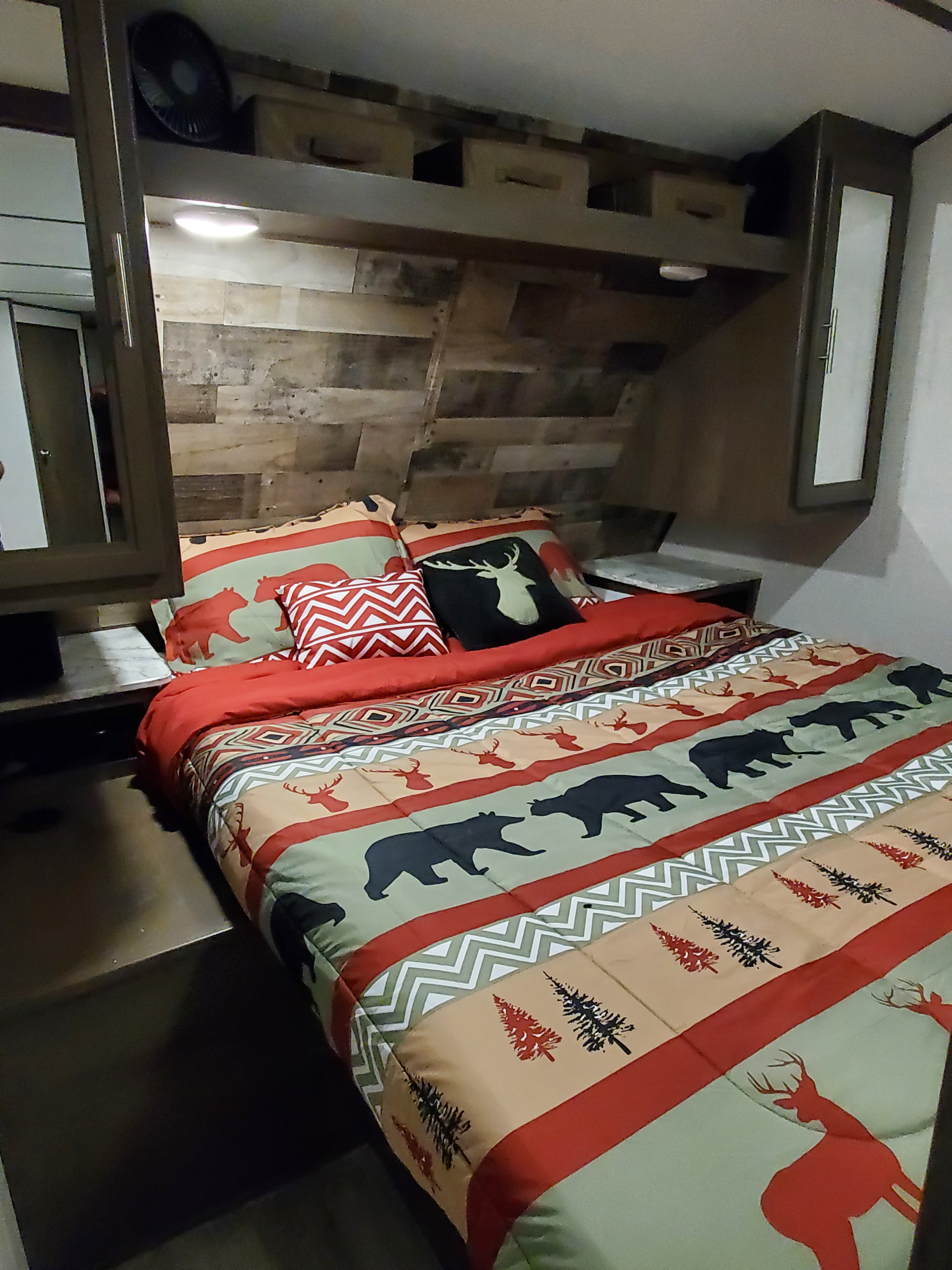Enjoy this rustic RV rental bedroom, featuring nature-themed bedding, wood paneling, and ample storage.. Dutchmen Aspen Trail 2020