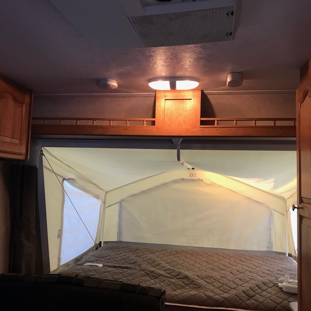 Cozy RV rental interior with an expanded pop-up bed, offering comfy camping.. Rockwood Roo 2011